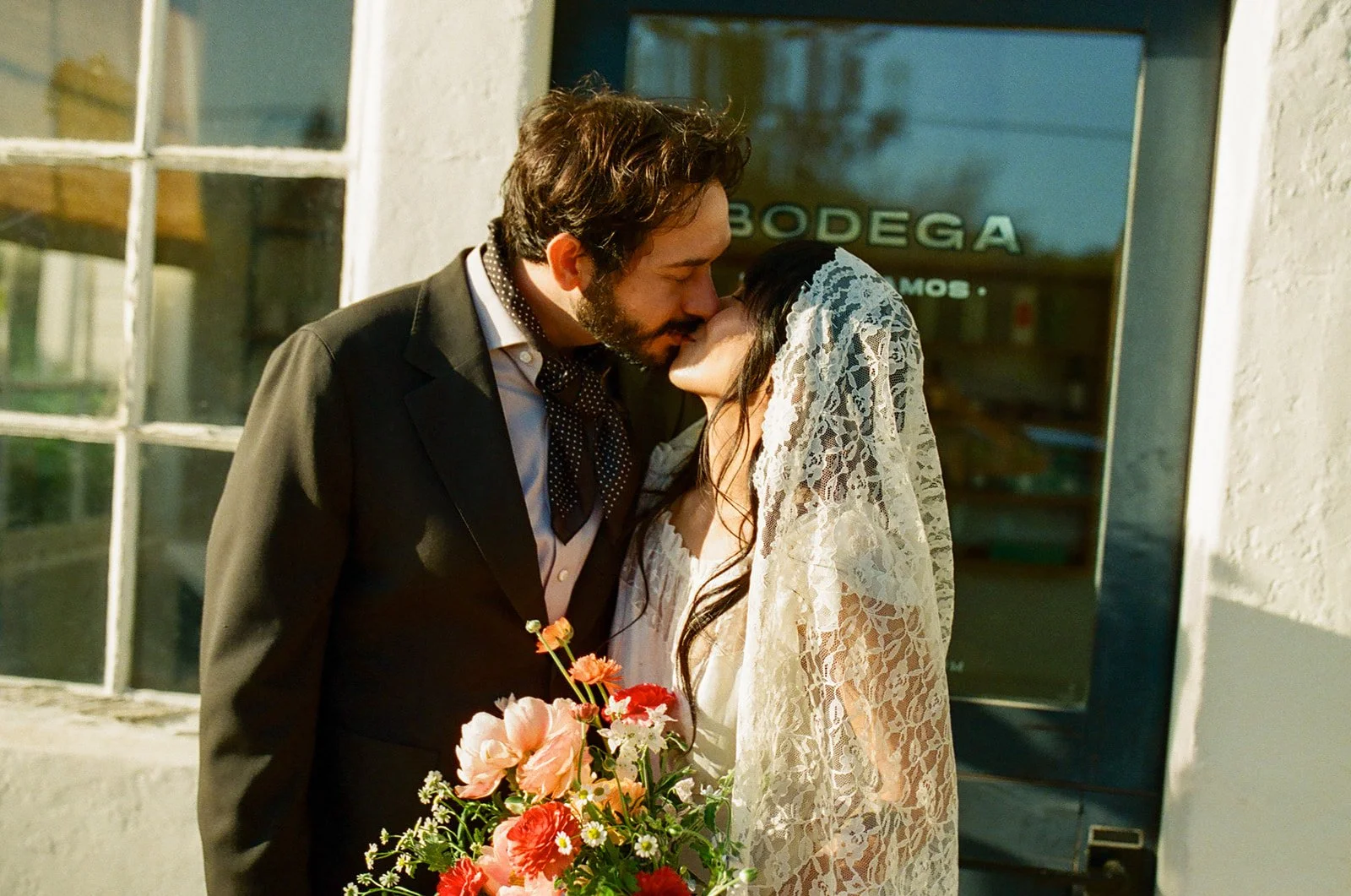 A couple kissing at their bodega wedding