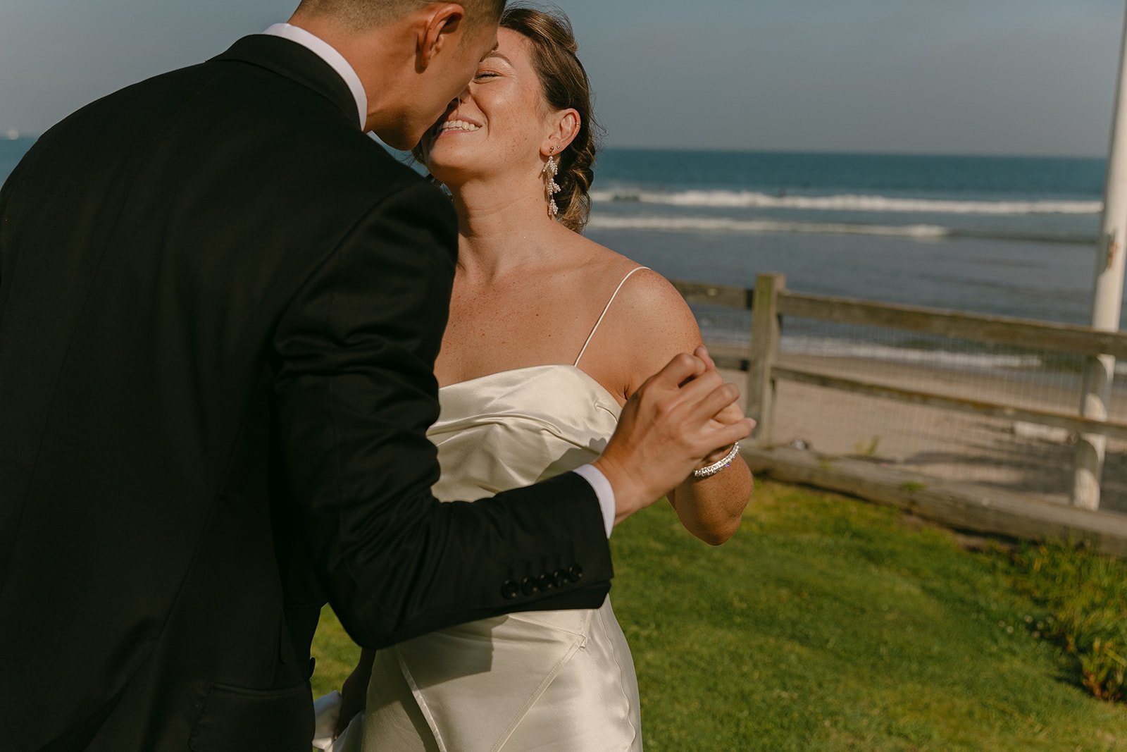 A candid wedding photo of a couple about to kiss