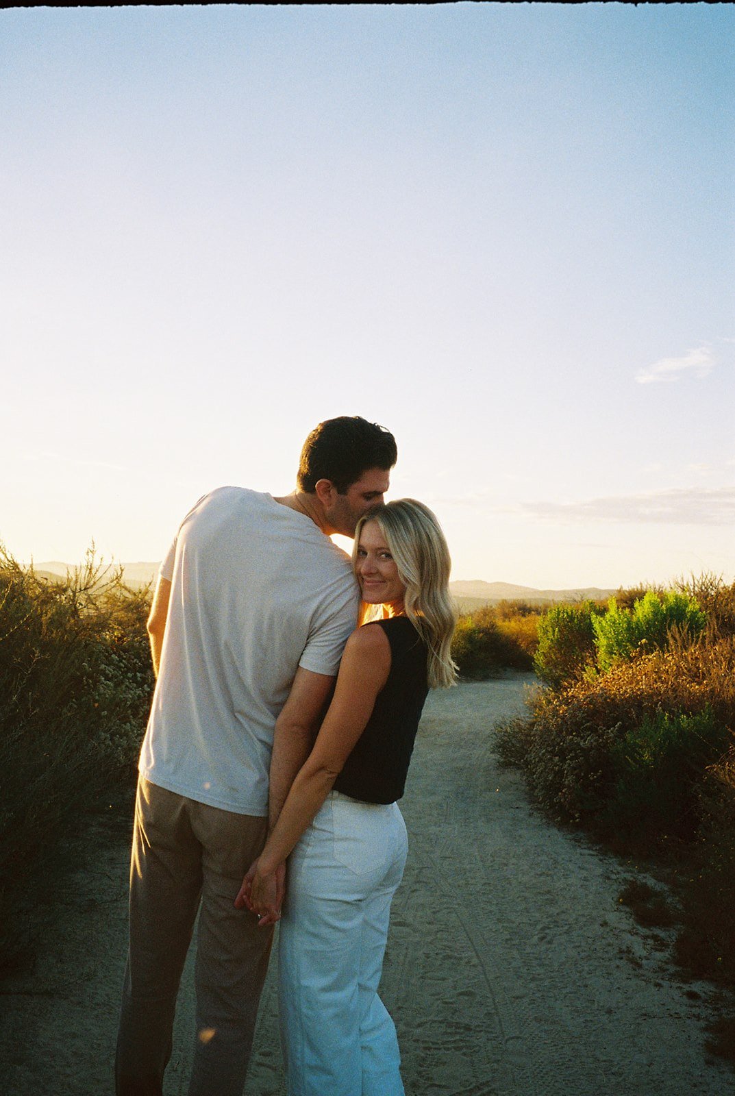 Couple laughing and walking hand-in-hand on a sunset beach stroll. Engagement photo tips show the magic of candid, relaxed moments.