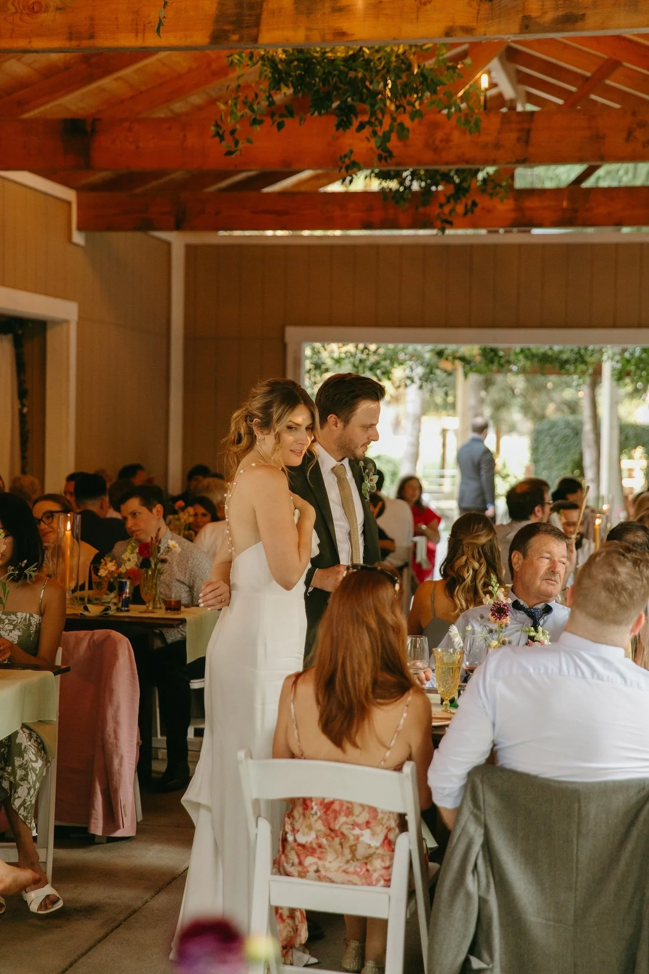 Couple stands together during the reception, greeting guests at their garden party wedding.