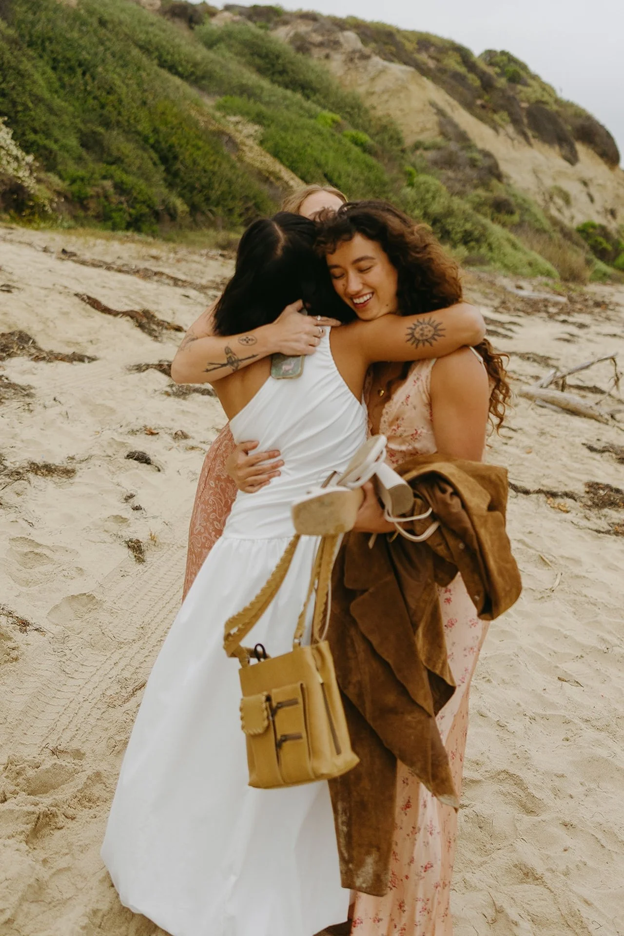 The bride hugging her bridesmaids on the beach during their elopement on the beach