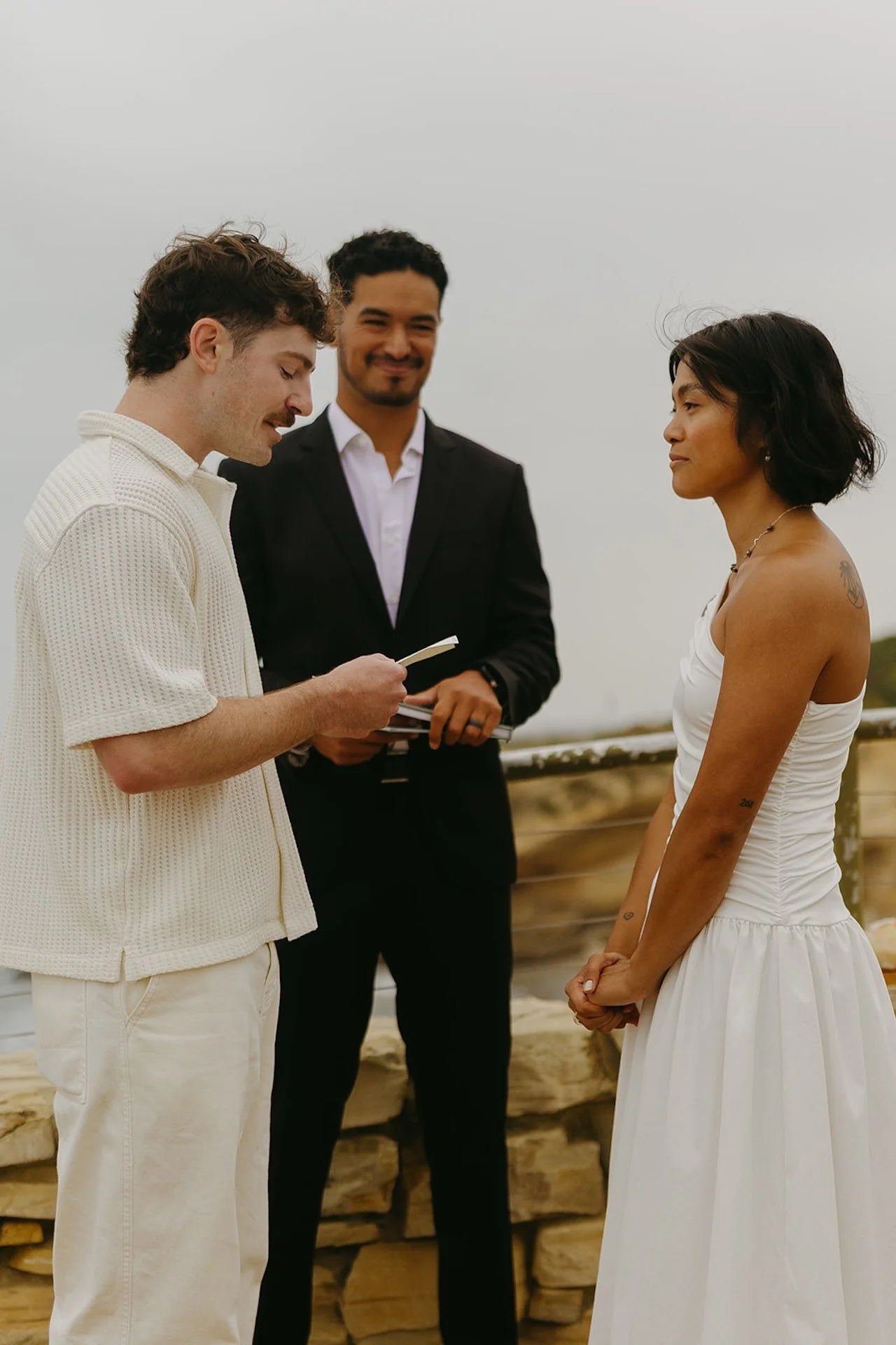 The groom reading his vows to the bride during their elopement on the beach