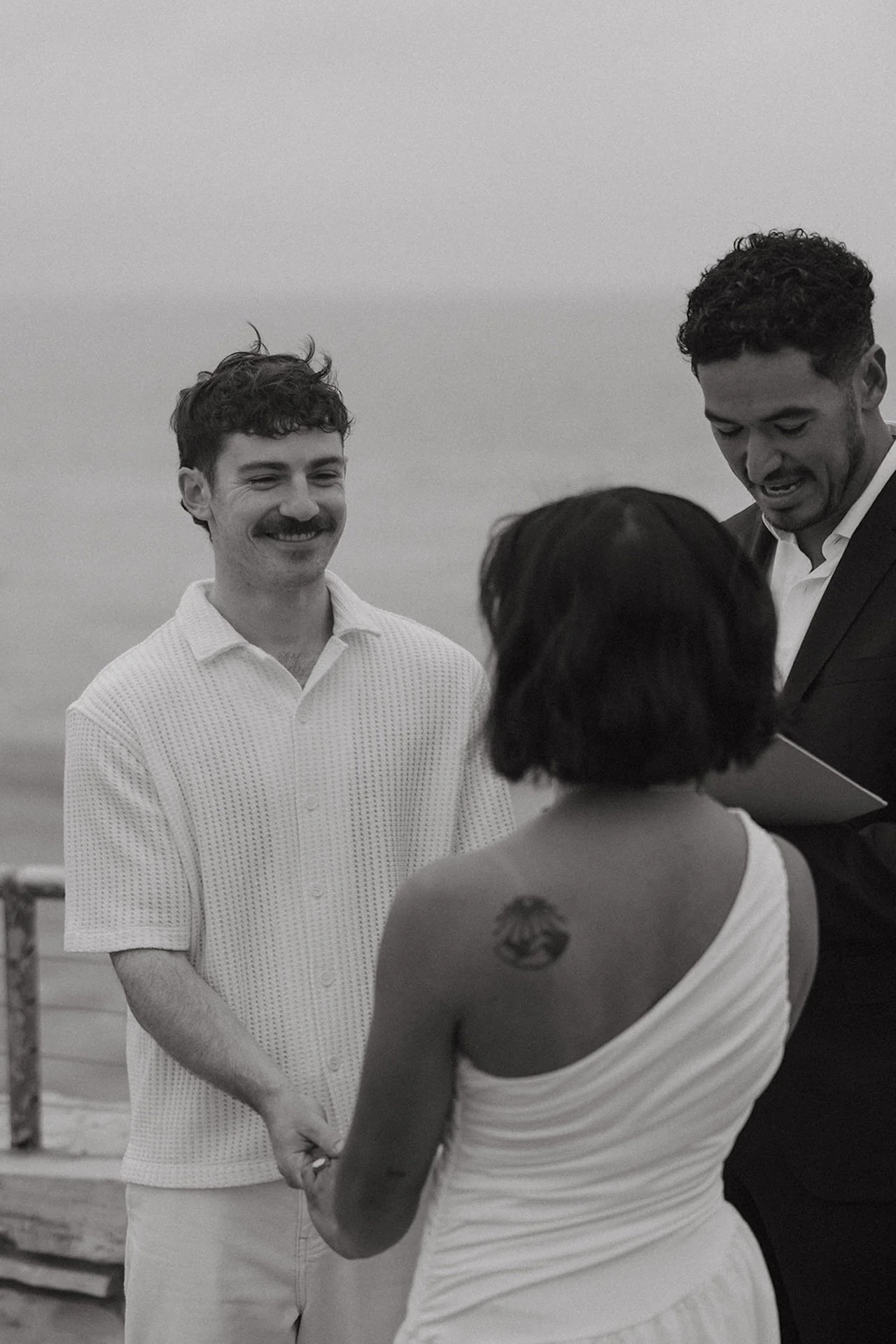 The bride and groom holding hands as they smile at each other during their ceremony