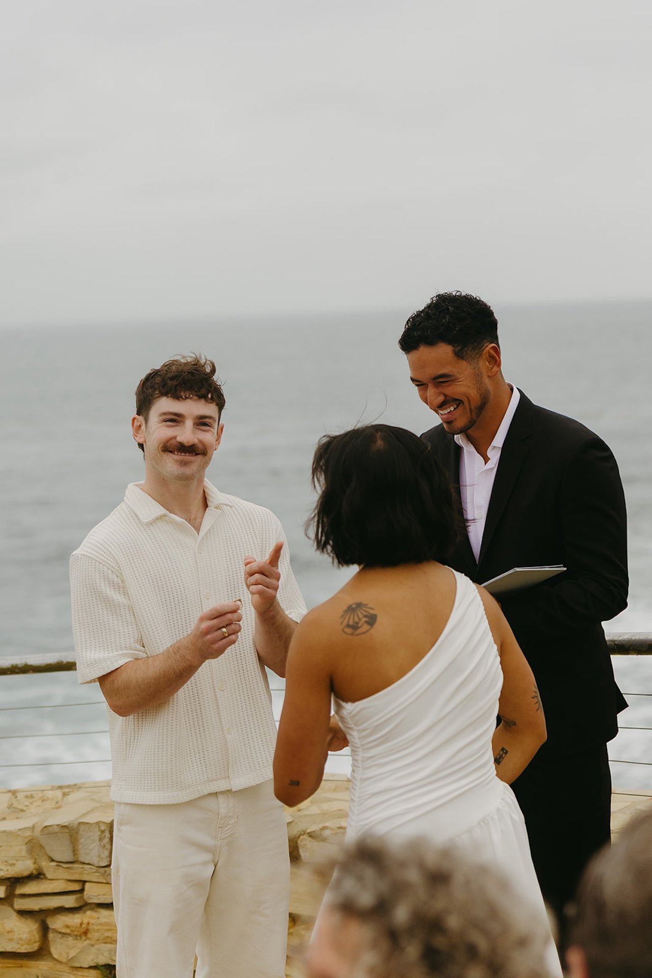 The bride and groom laughing during their ceremony as the officiant reads their vows