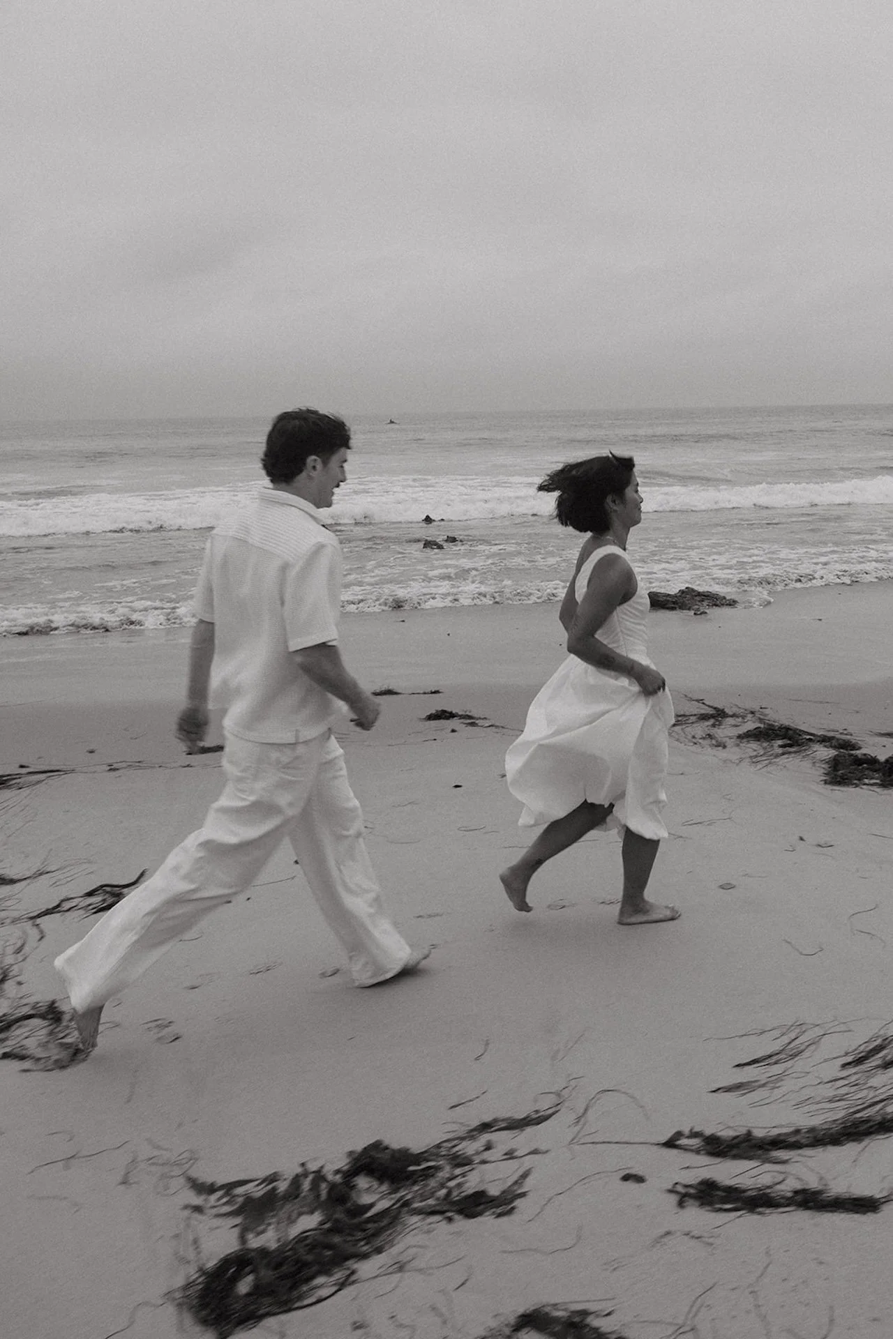 A candid shot of the bride and groom running together during their elopement on the beach