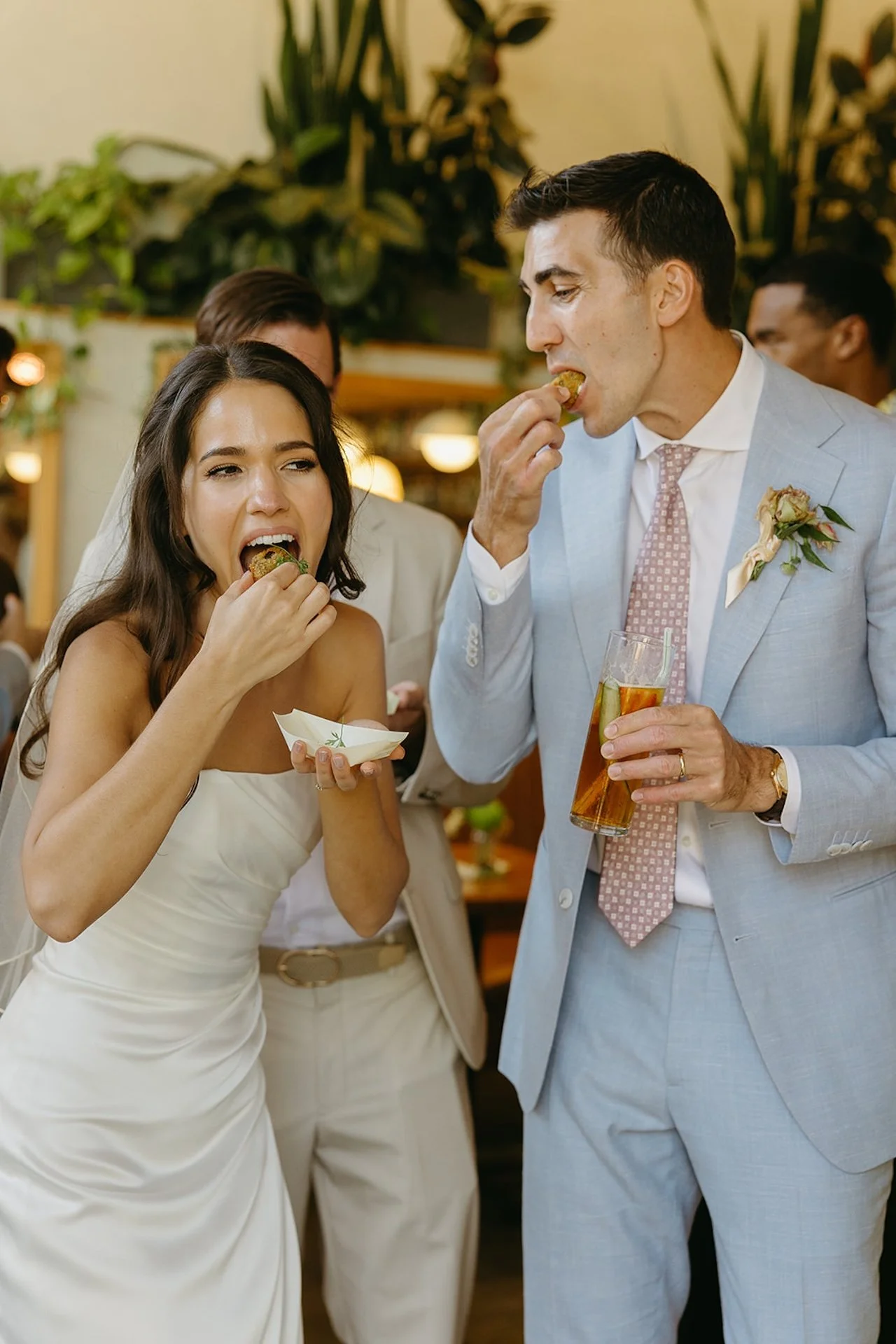 The bride and groom eating appetizers and drinking cocktails during their wedding reception at their restaurant, The Mayfield