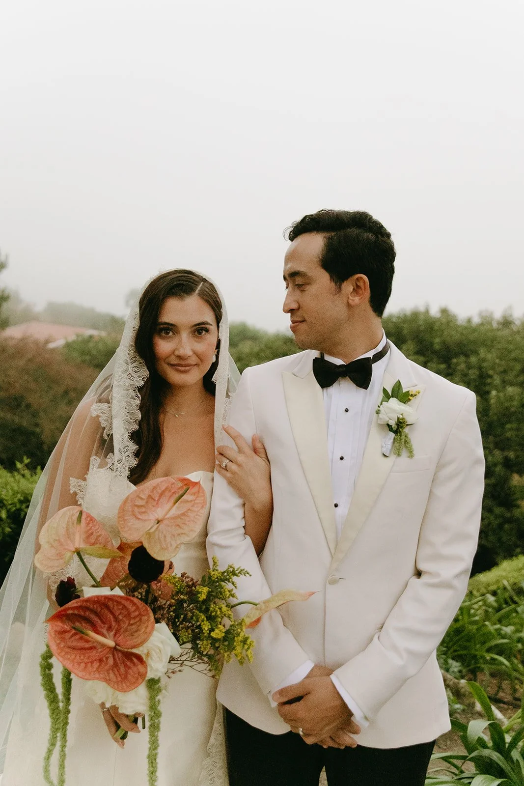 Bride and groom standing arm in arm, looking at each other during portraits at a Palos Verdes wedding venue.
