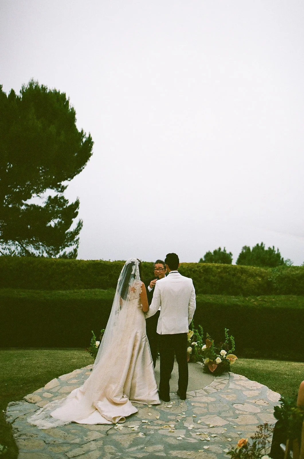Wide view of the ceremony space as the couple stands hand in hand during their vows at a Palos Verdes wedding venue.