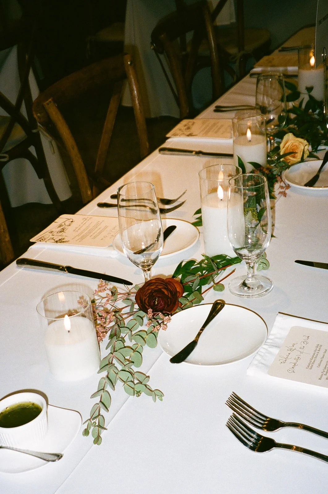 Long dinner table styled with candles, menus, and floral centerpieces at a Historic Wedding Venue.