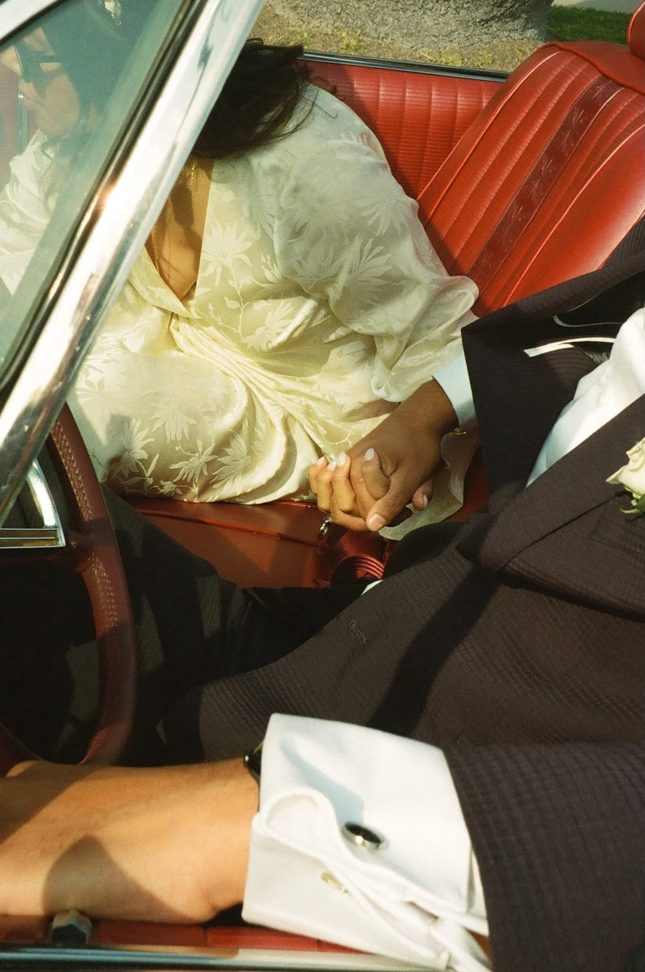 Detail photo of the bride and groom holding hands in the front seat of their convertable during their Beverly Hills Courthouse Elopement photos