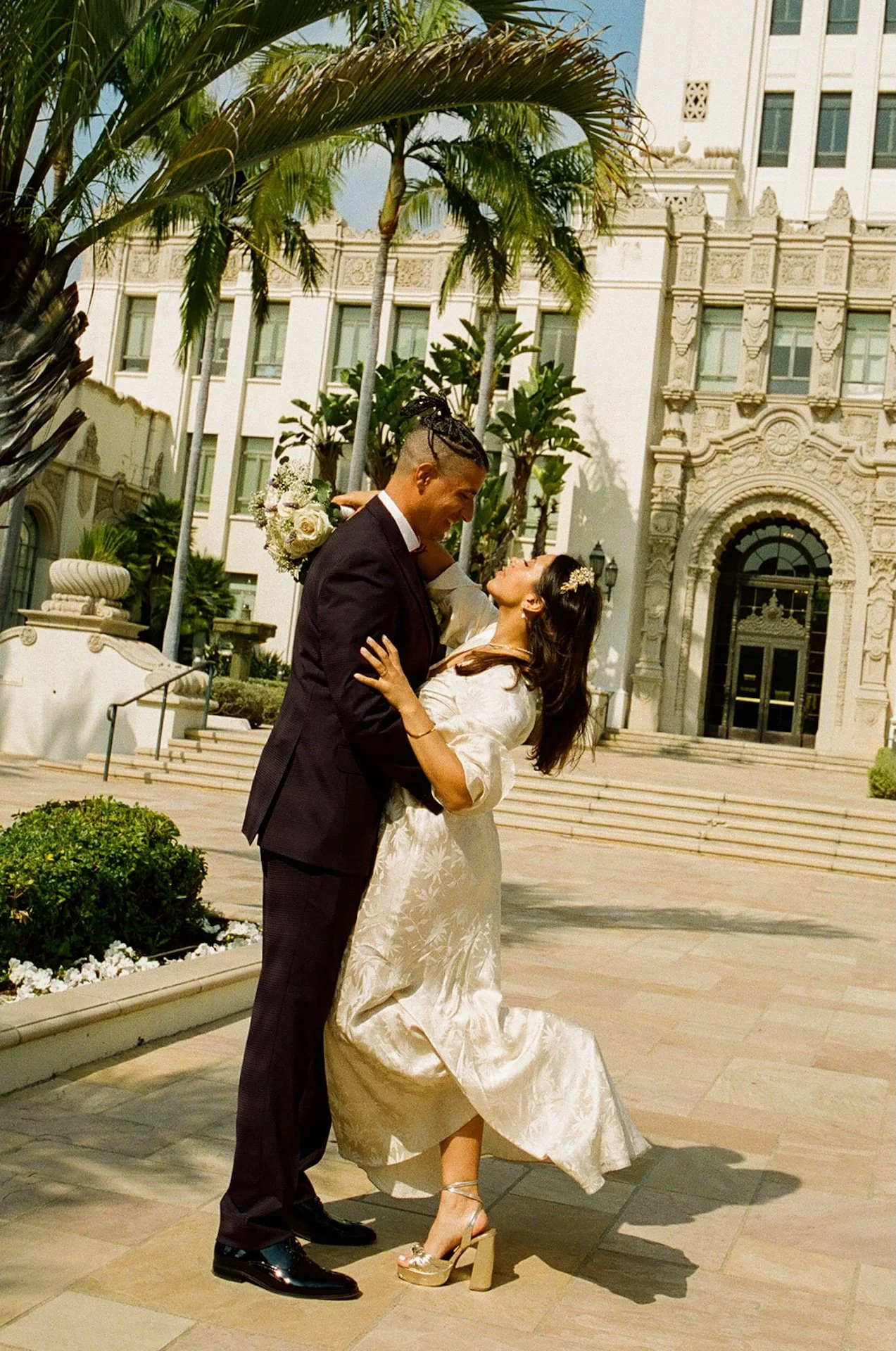 Newlyweds taking couple portraits outside of the Beverly Hills Courthouse after their Beverly Hills Courthouse Elopement