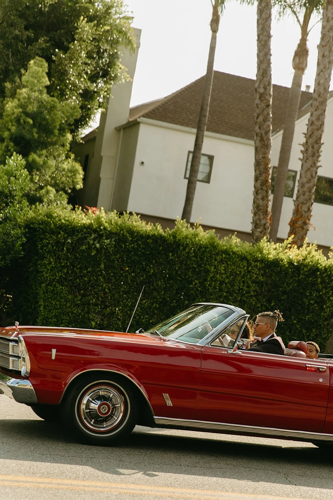 The bride and groom driving in a red convertable they rented after their Beverly Hills Courthouse Elopement