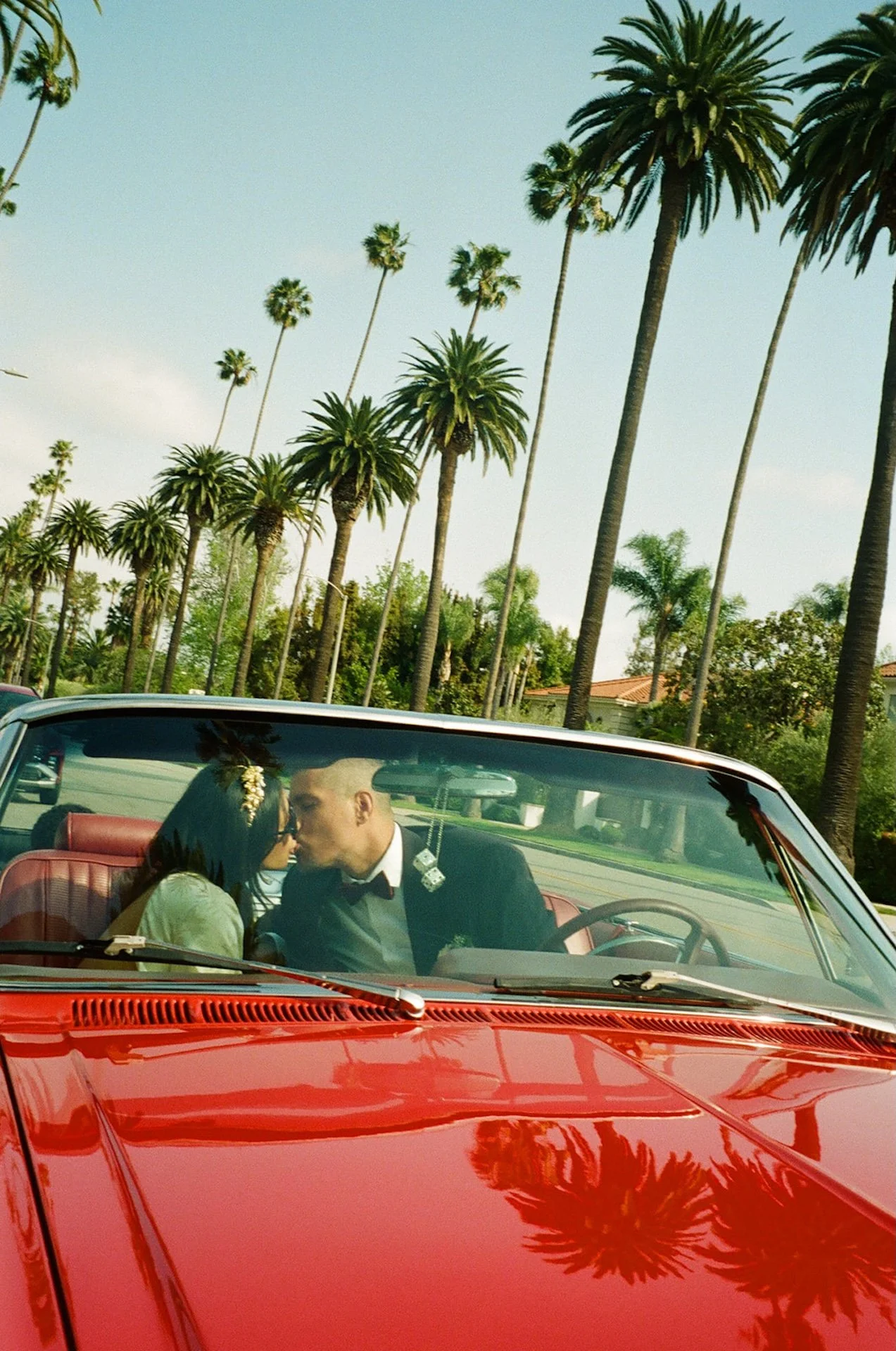 bride and groom kissing in the front seat of a red convertable during their couple portraits after a Beverly Hills Courthouse Elopement