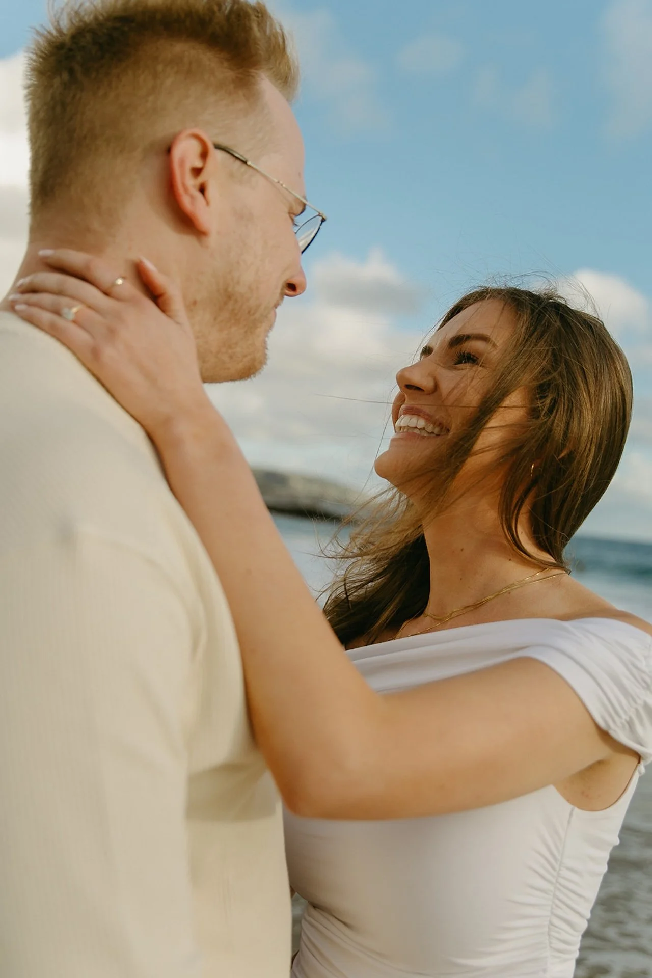Intimate portrait of the couple facing each other near the ocean, her hands around his neck during laguna beach engagement photos at shaws cove laguna beach.
