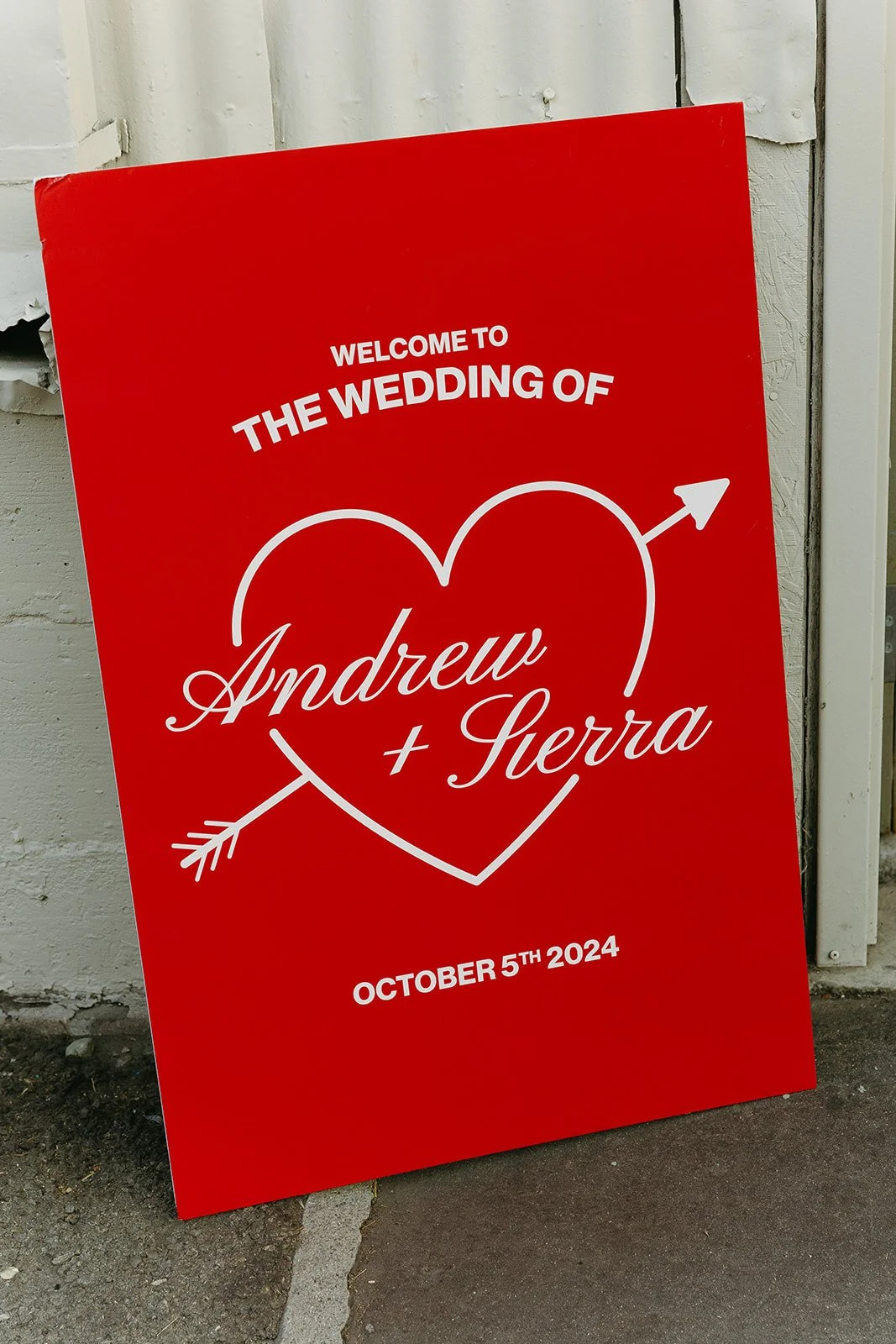 A bold red welcome sign outside The Revery LA welcoming guests to the wedding of Andrew and Sierra.