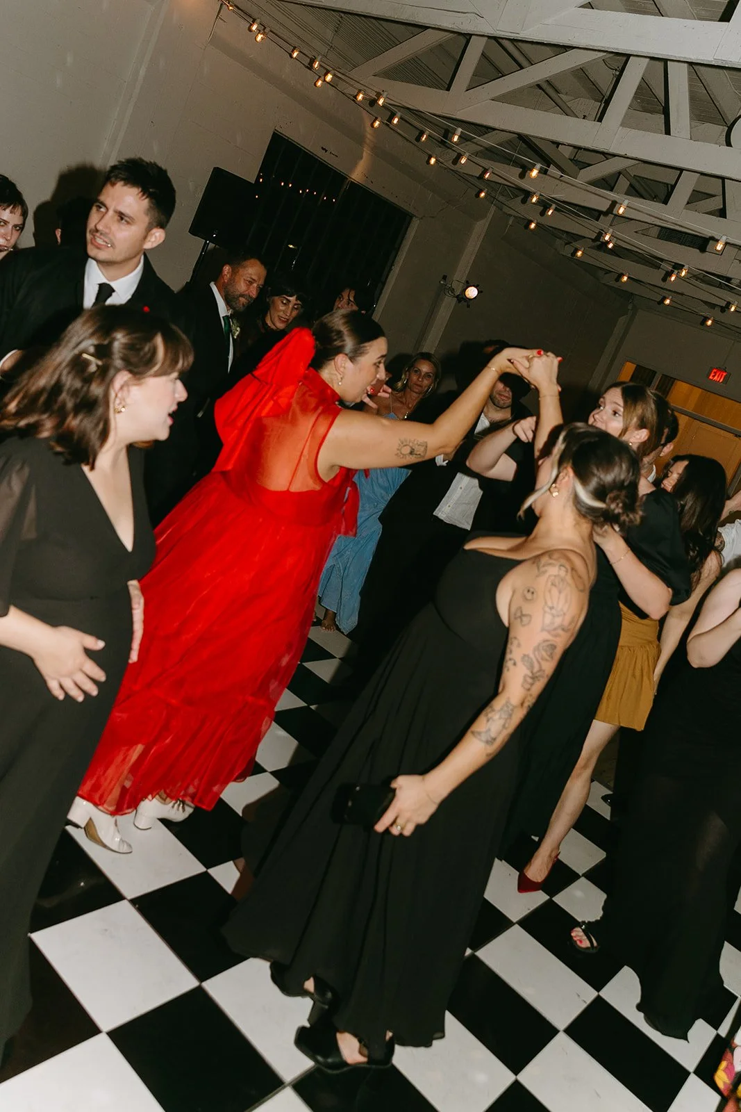 Guests dancing together on the black and white checkered floor at The Revery LA during the reception.