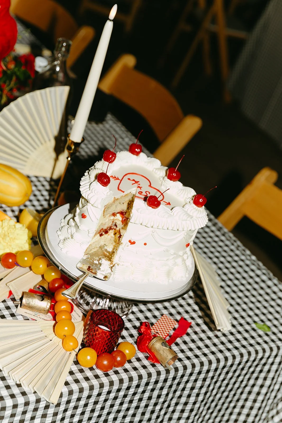 The classy, white, vintage, wedding cake with a slice taken out of it at The Revery LA, smiling and leaning in during the reception.