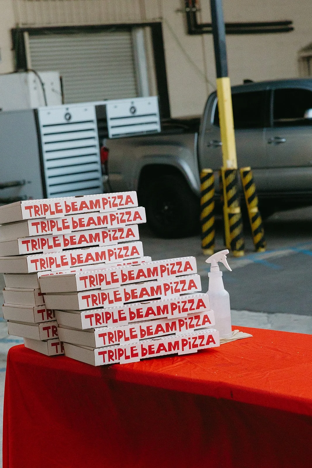 A stack of pizza boxes labeled “Triple Beam Pizza” set out during the reception at The Revery LA.