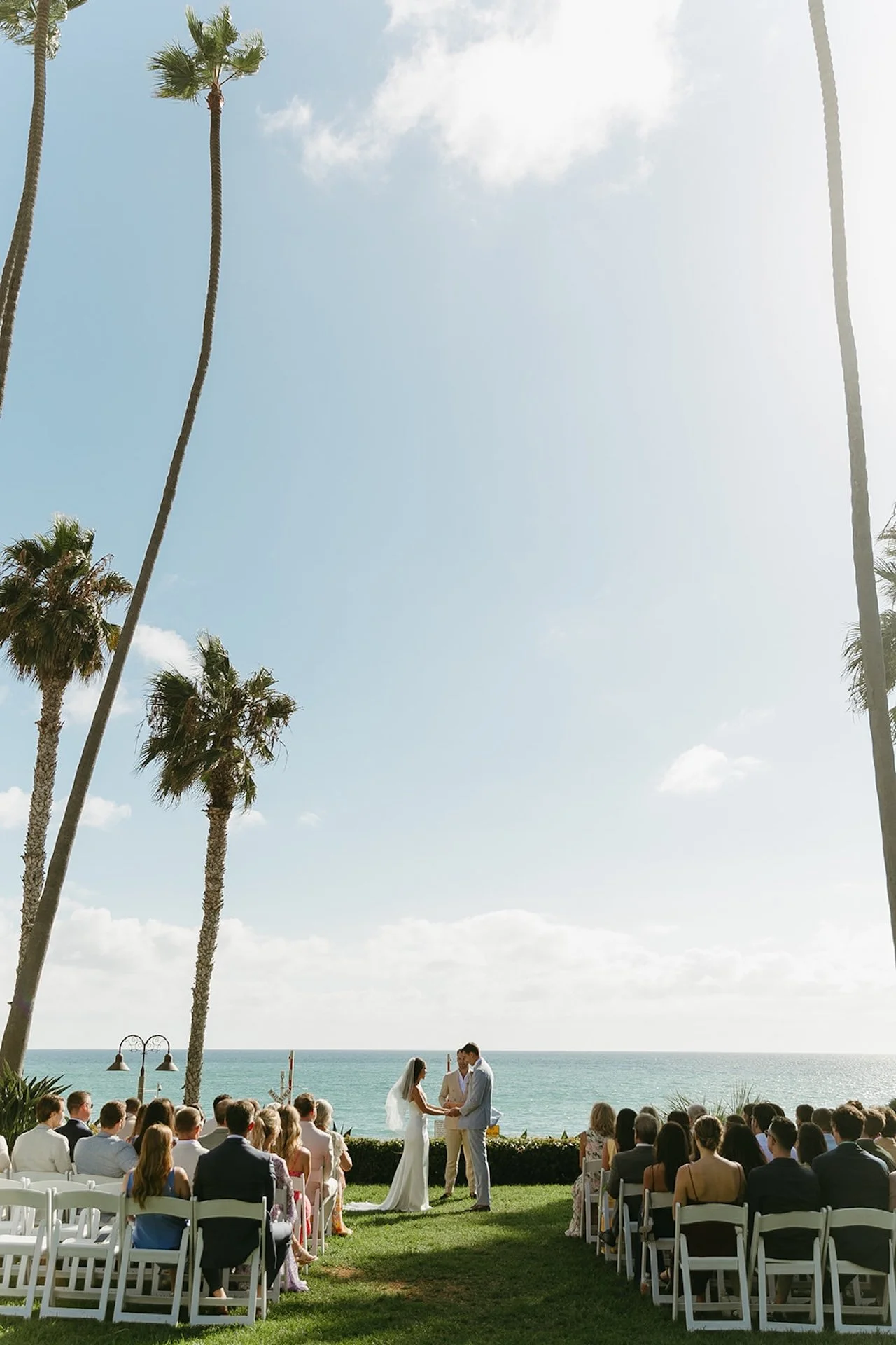 Outdoor ceremony framed by tall palm trees and ocean views at one of the most iconic San Clemente Wedding Venues.