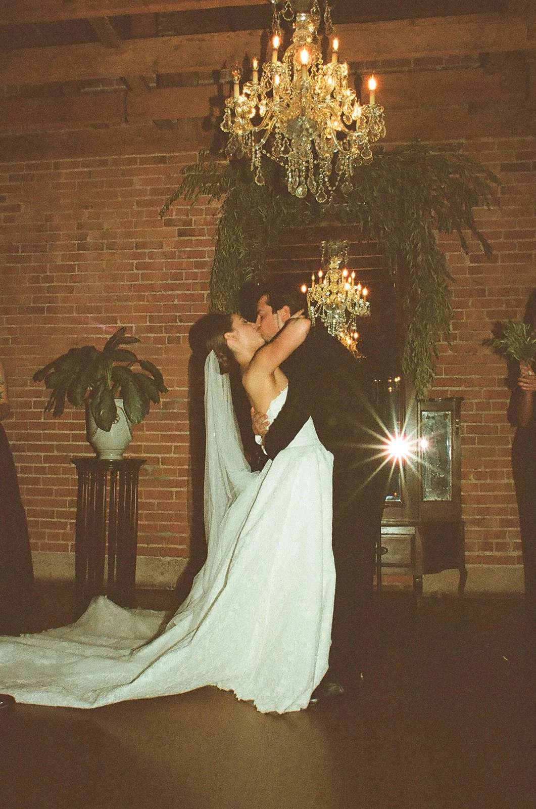 The bride and groom sharing their first kiss during their moody wedding ceremony at the Carondelet House 