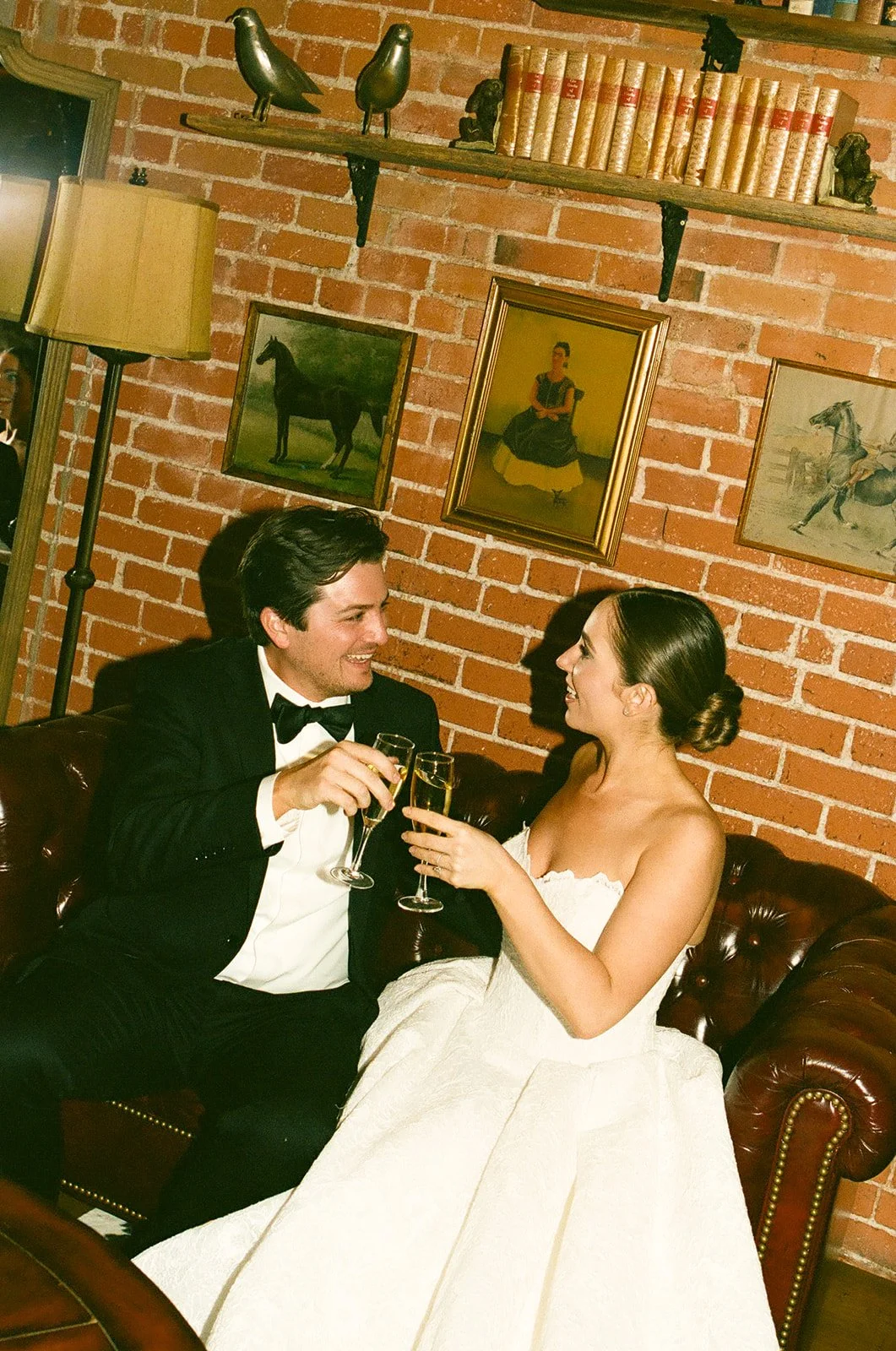 A bride and groom cheersing champagne glasses during their bride and groom portraits