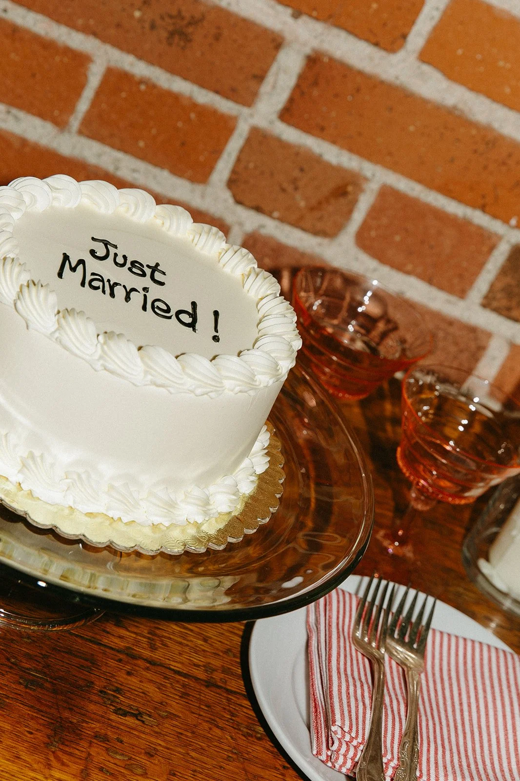 A flash photo of an elegant white wedding cake that says "Just Married" On it