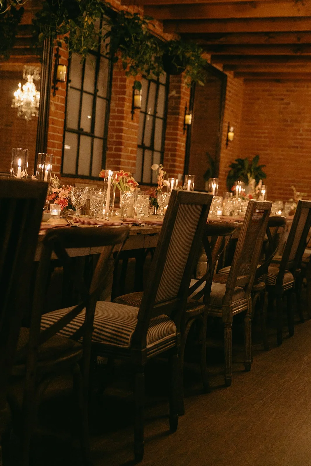 A candlelit italian inspired wedding reception table setup in a long room at the Caraondelet House, a DTLA wedding venue