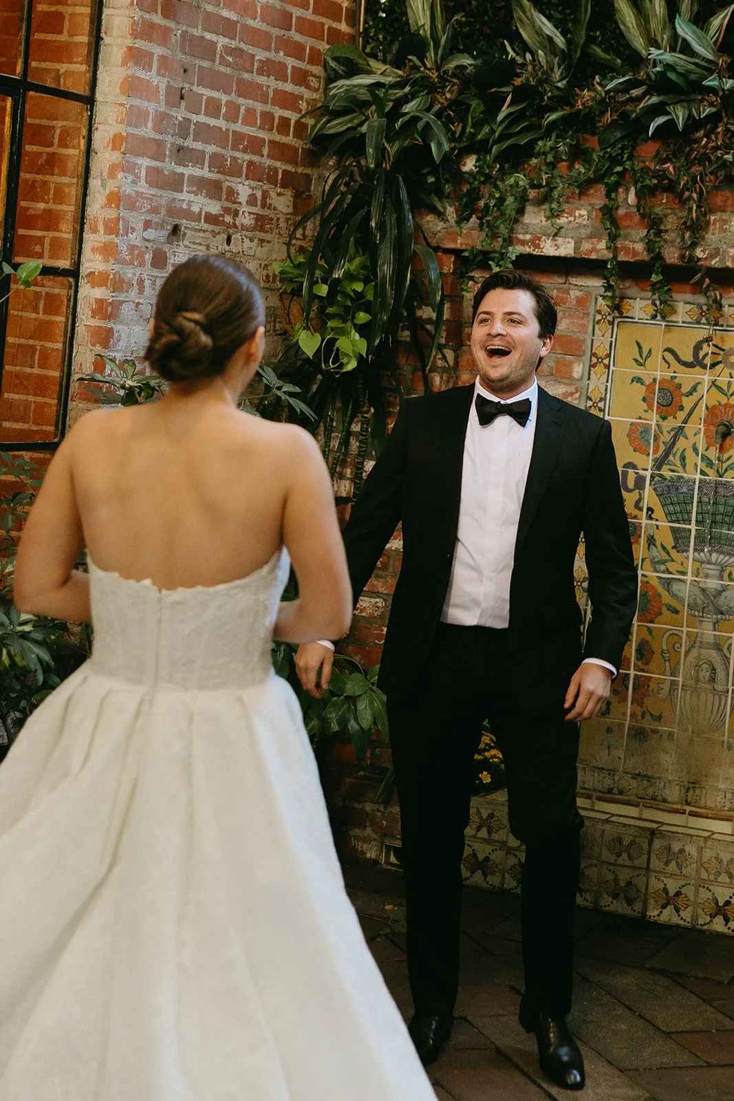 The groom smiling at his bride as he sees her for the first time during their first look at a DTLA wedding venue