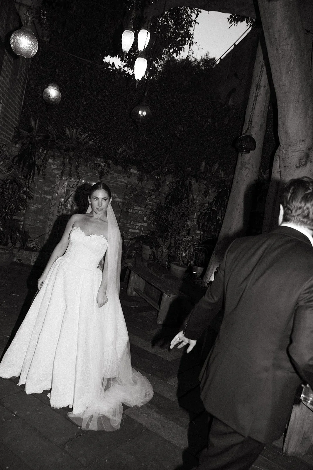 The bride standing in the courtyard at the Carondelet house in dtla and walking towards her husband