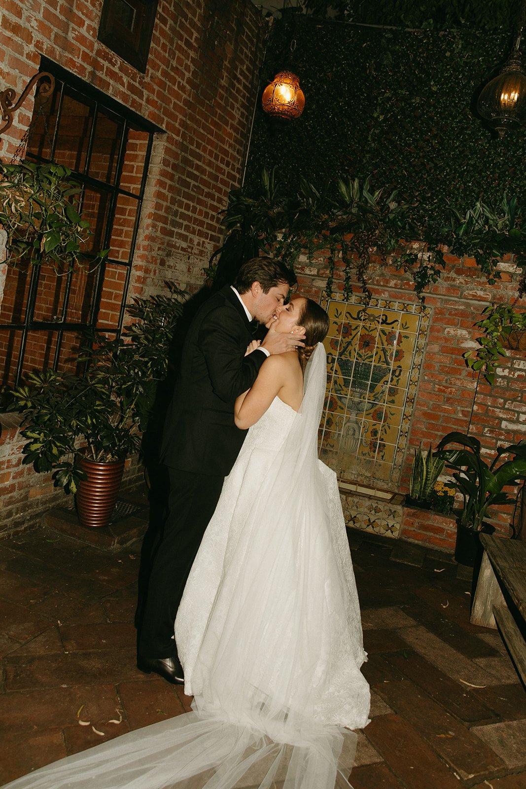A bride and groom smiling and sharing a kiss during their bride and groom portraits at a  DTLA wedding venue