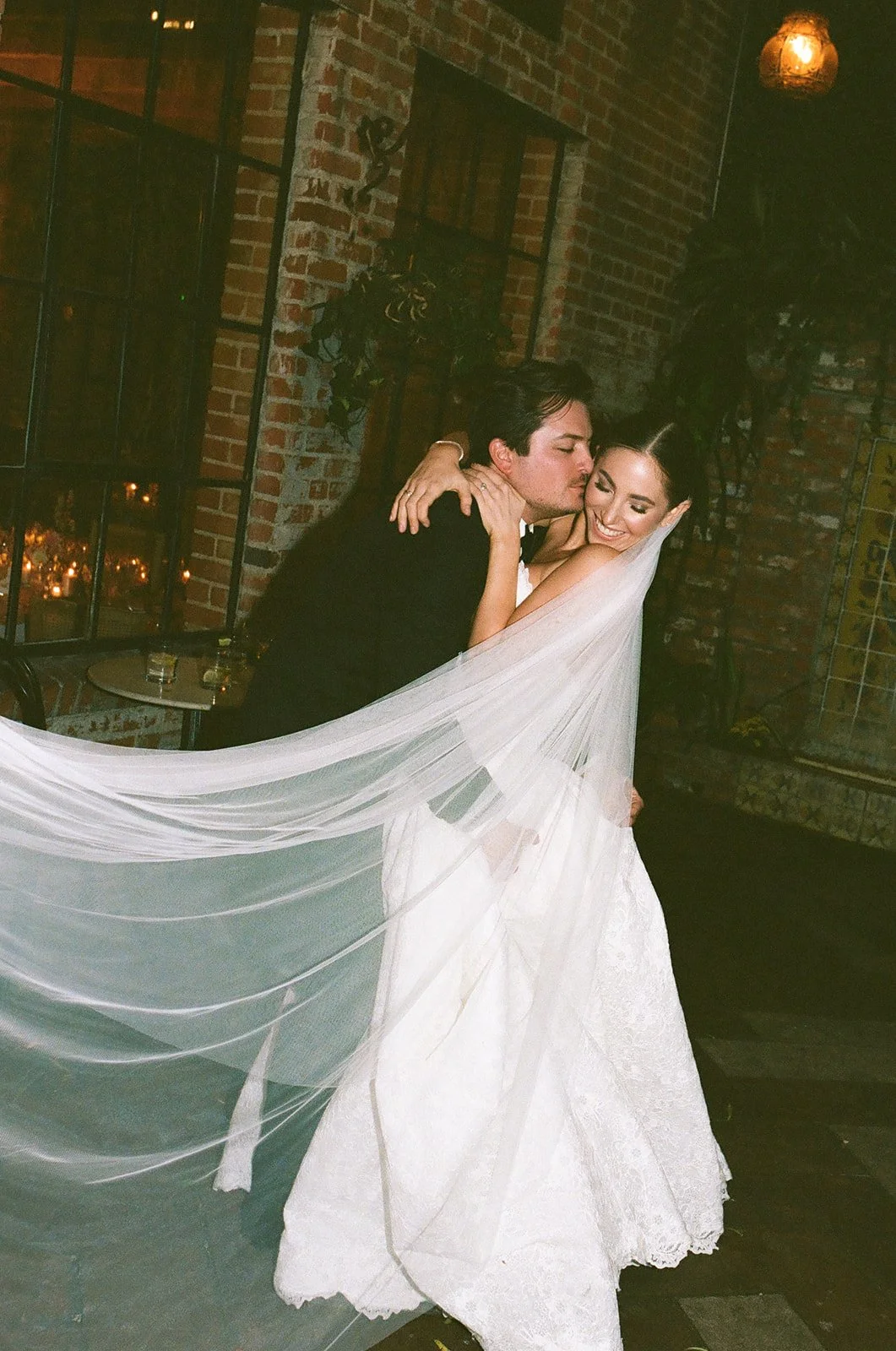 A film photo of the bride and groom hugging onto each other in the courtyard at their  DTLA wedding venue
