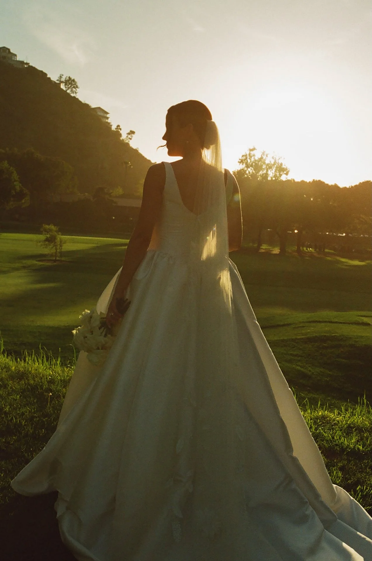 Bride silhouetted at golden hour overlooking the canyon landscape at The Ranch at Laguna Beach wedding.