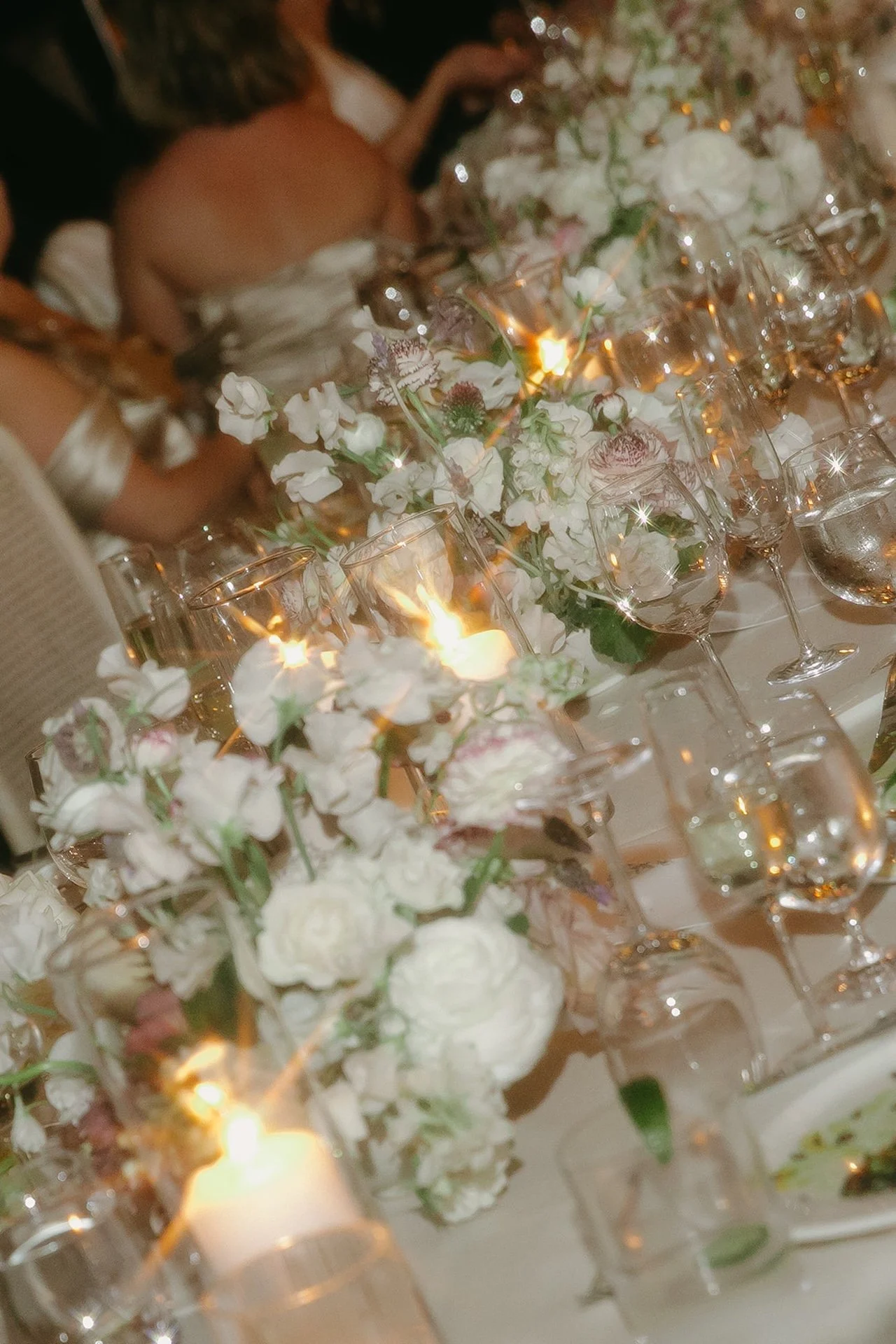 Candlelit reception table details with glassware, florals, and warm ambient lighting at The Ranch at Laguna Beach wedding.