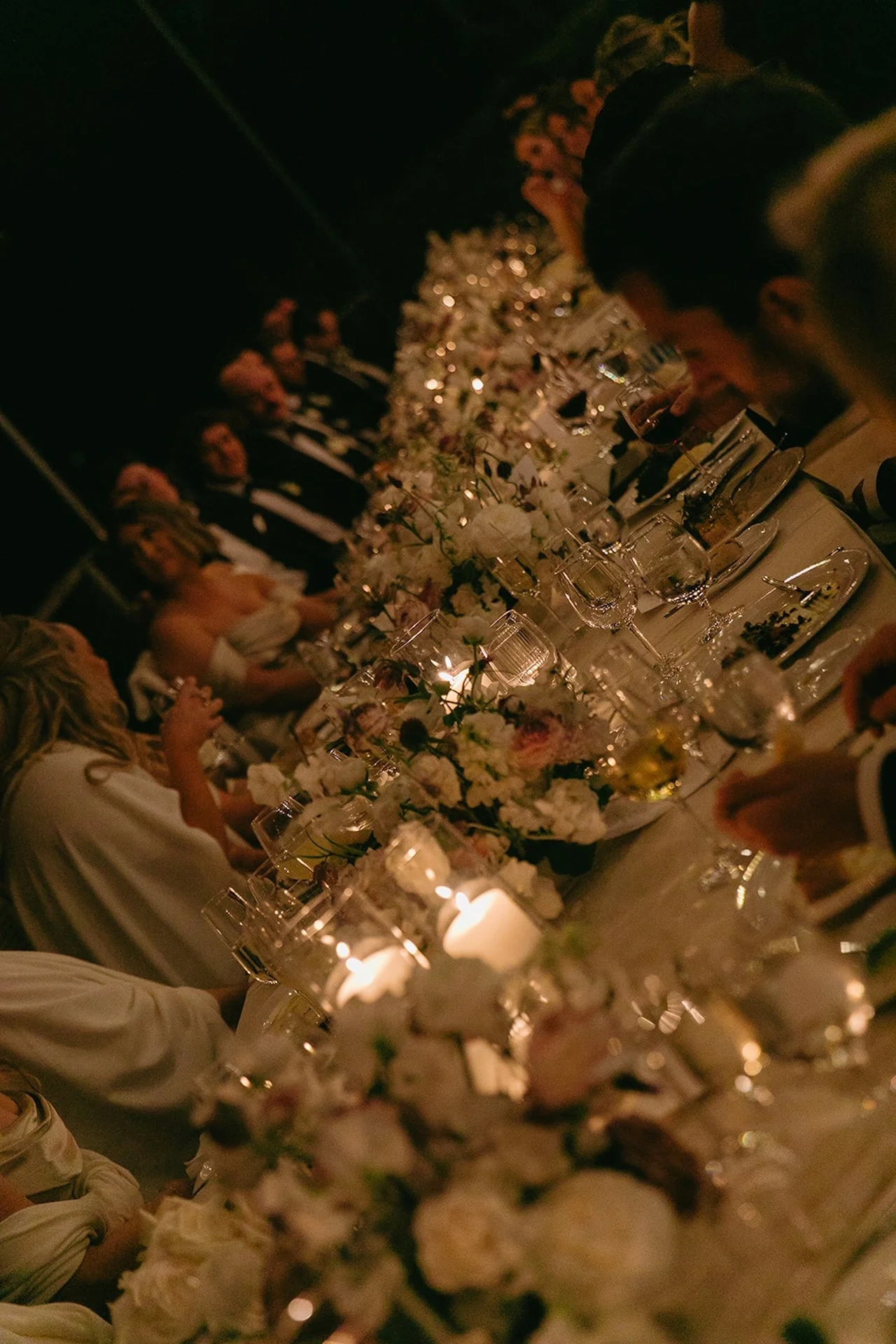 Wedding guests seated for dinner beneath string lights during an intimate reception at The Ranch at Laguna Beach wedding.