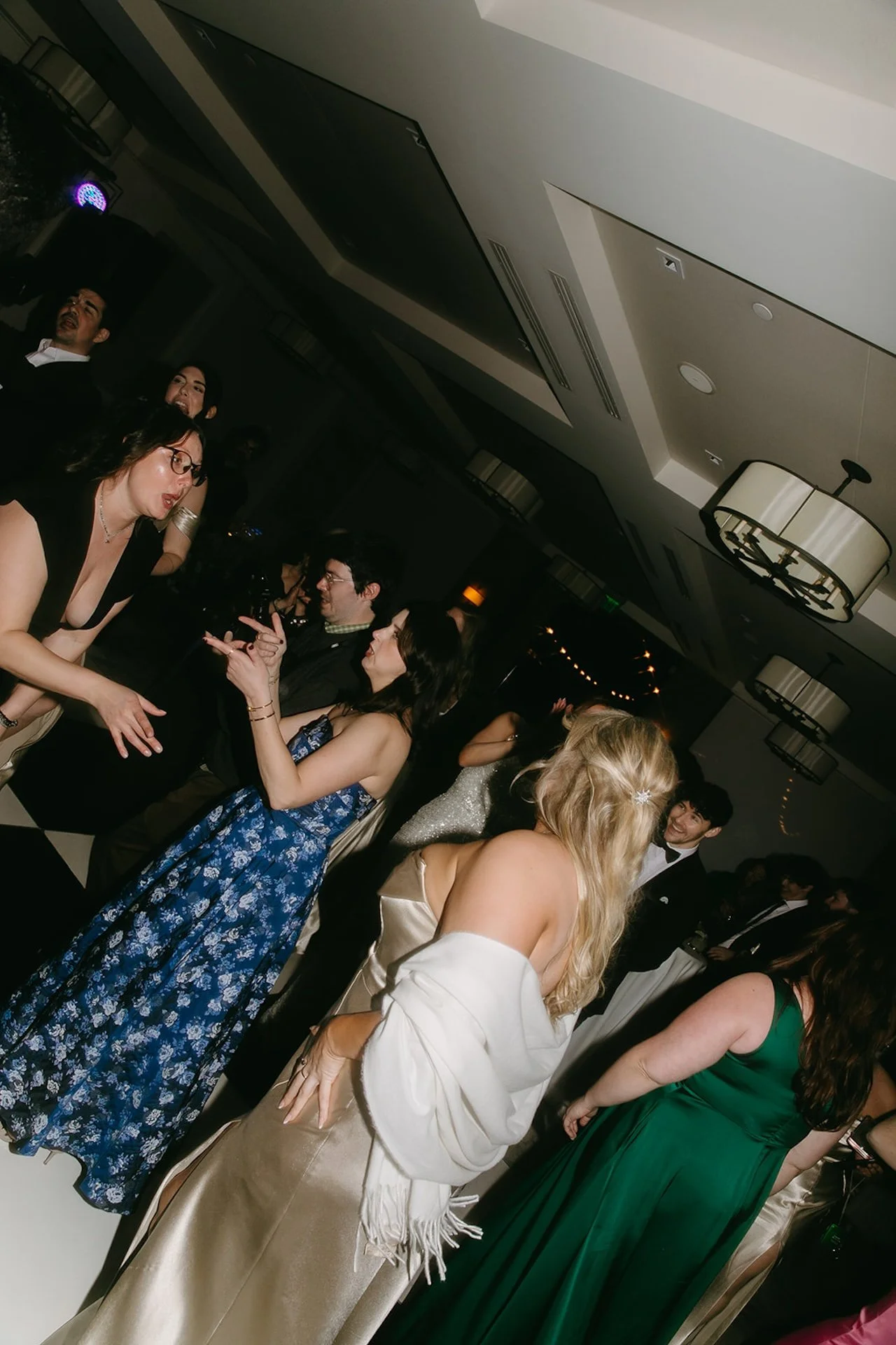 Guests dancing on the reception dance floor beneath chandeliers and party lighting at The Ranch at Laguna Beach wedding.