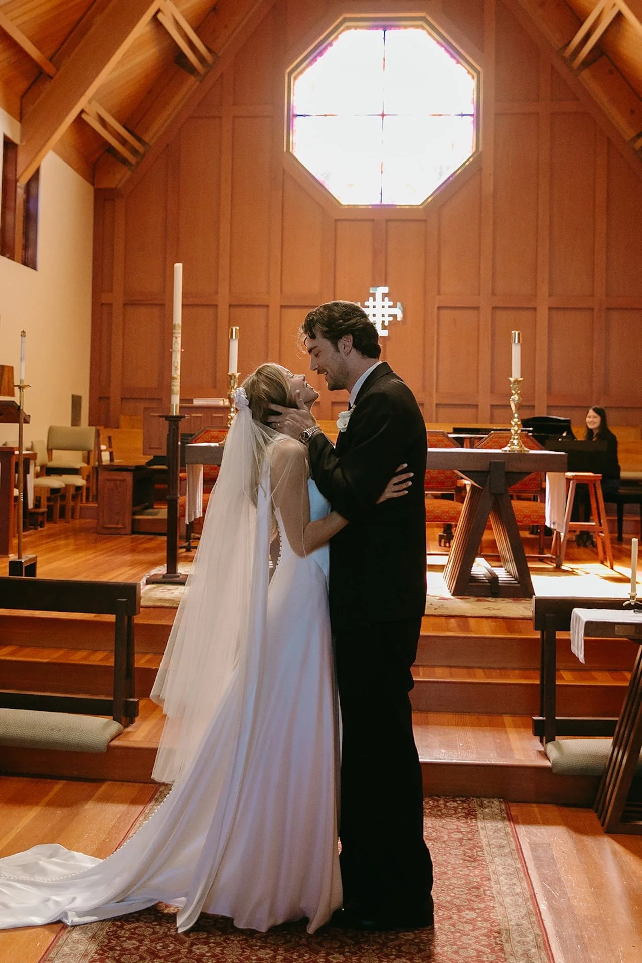 Bride and groom embracing and sharing a joyful kiss at the altar following their Laguna Beach wedding ceremony.