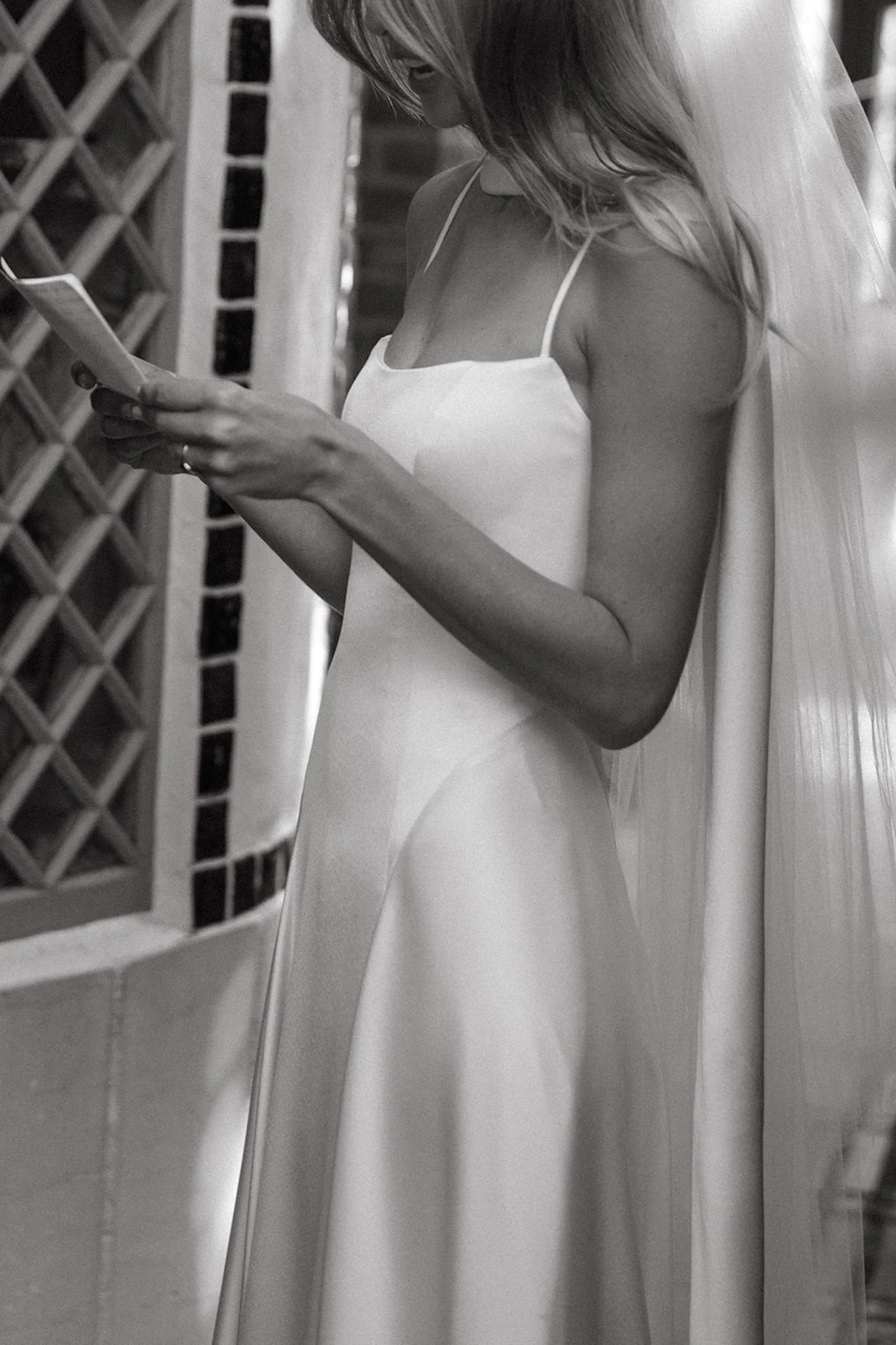 Black and white portrait of the bride reading her vows during an emotional Laguna Beach wedding first look.