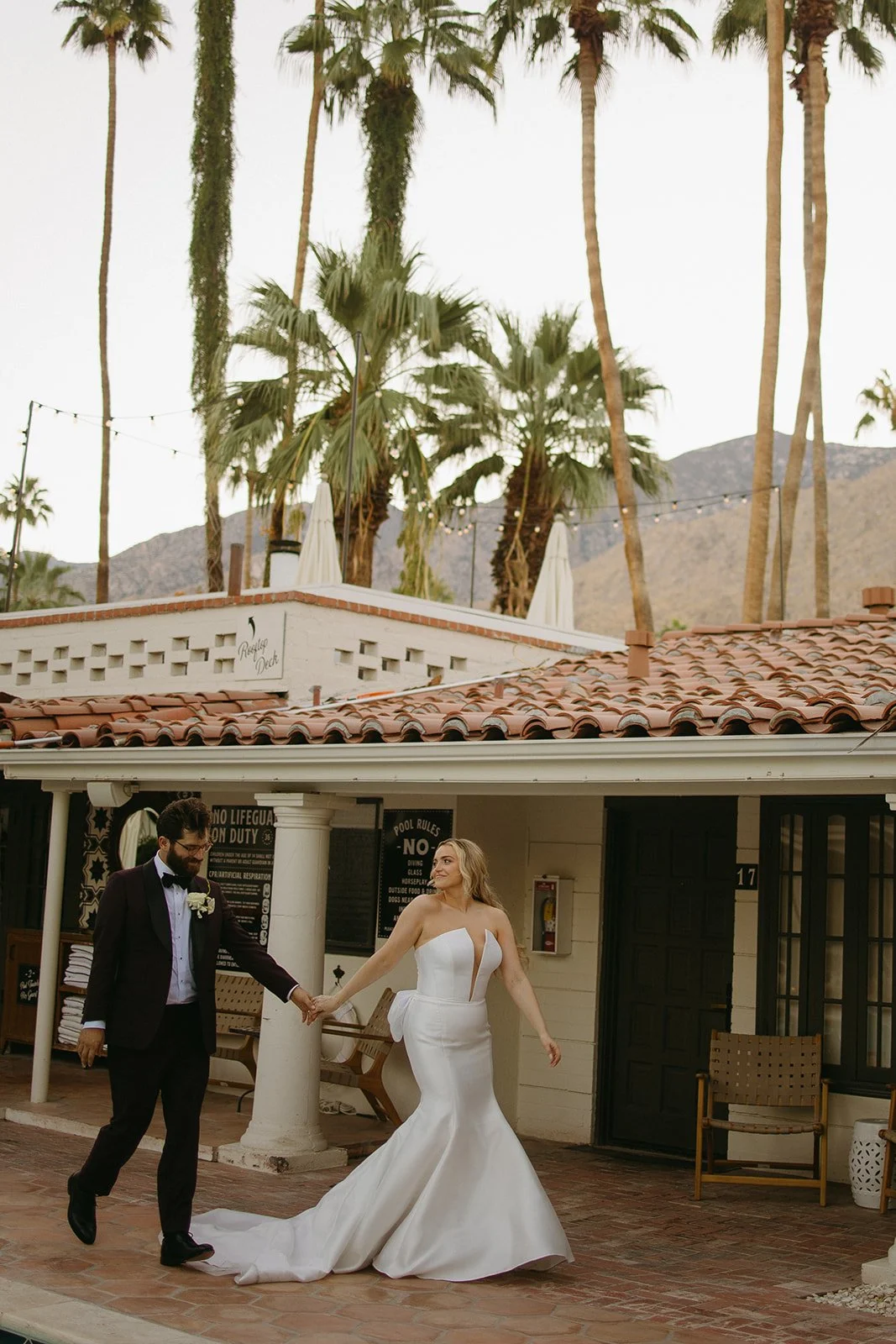 A bride and groom walking holding hands at their Palm Springs wedding venue, Villa Royale