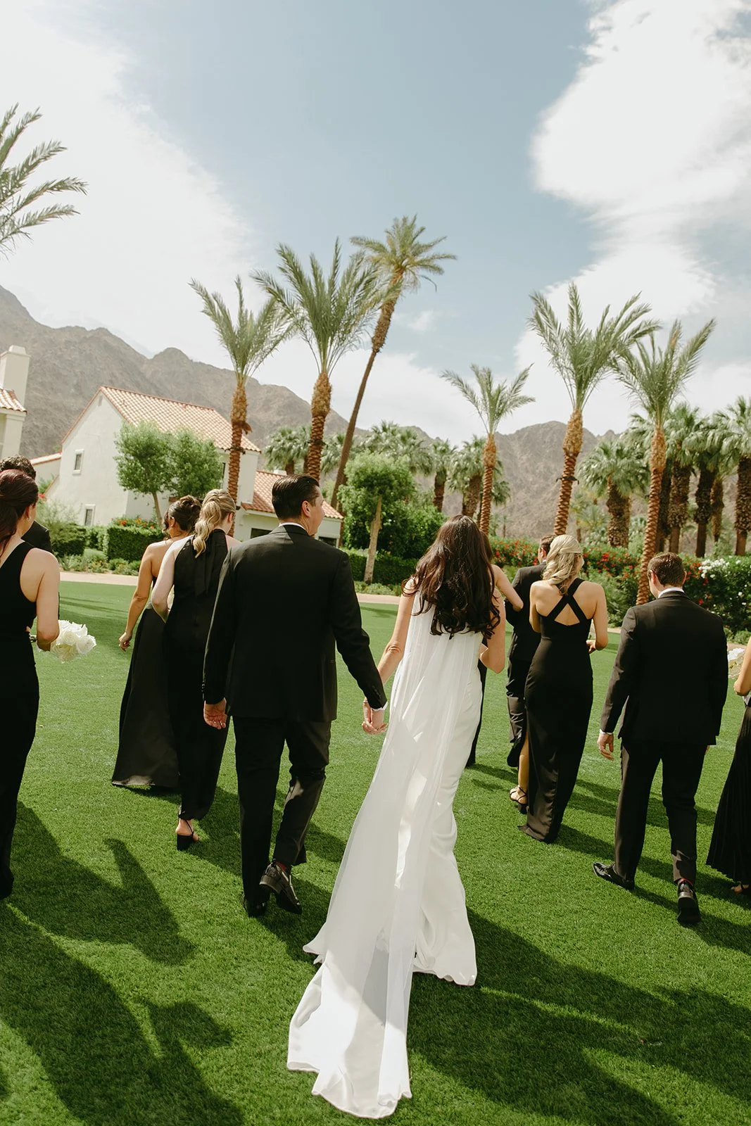 A wedding party walking across the lawn at Palm Springs wedding venue PGA West