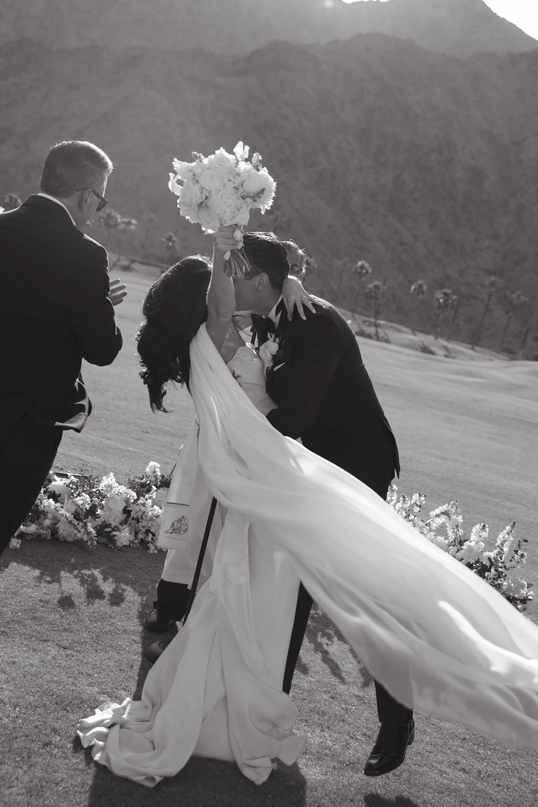 A black and white photo of a bride and groom kissing at their Palm Springs wedding venue
