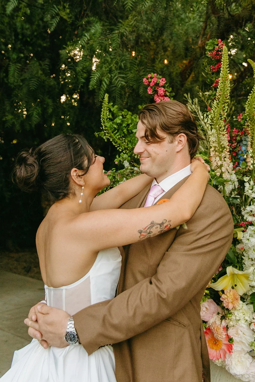 A bride and groom posing for photos at their unique wedding venue, the fig house
