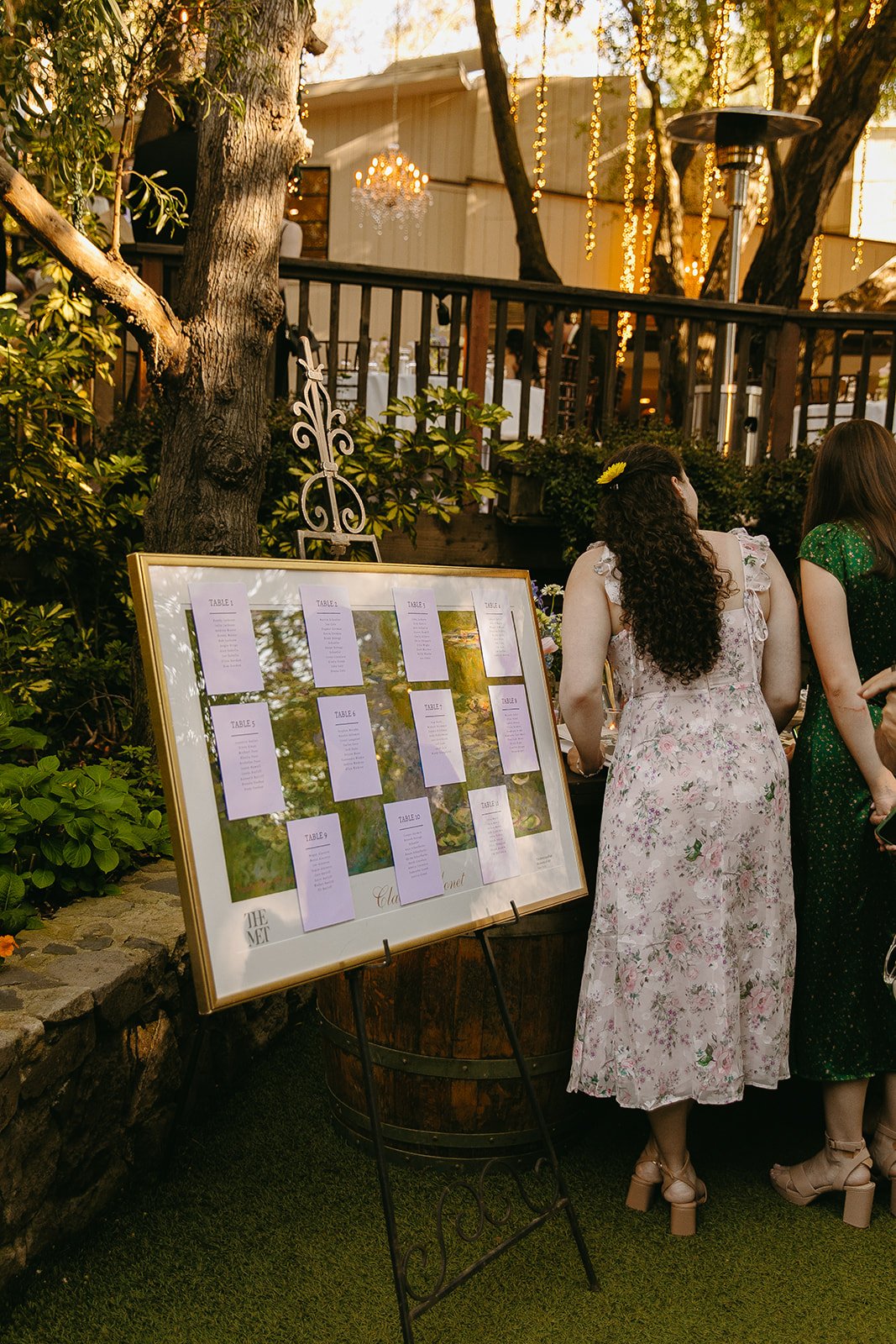Wedding guests siging a guest book at an outdoor wedding reception