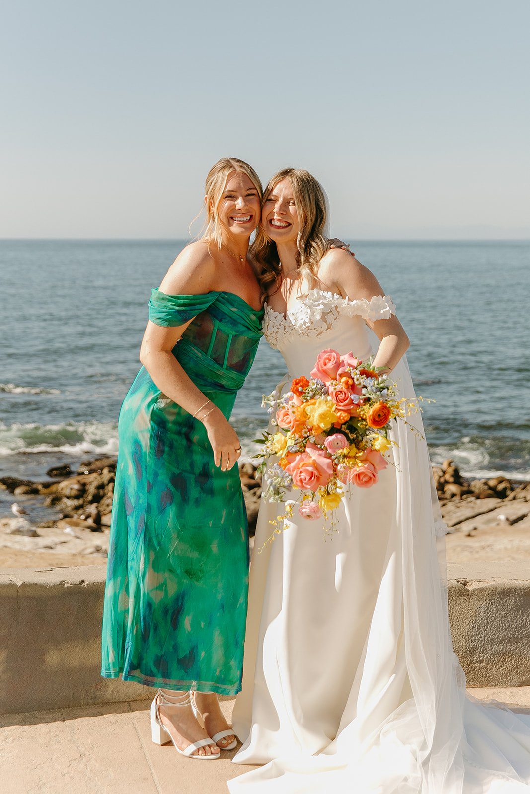 A bride and bridesmaid posing for wedding photos
