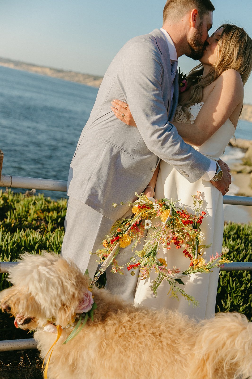 A bride and groom taking wedding photos with their dog