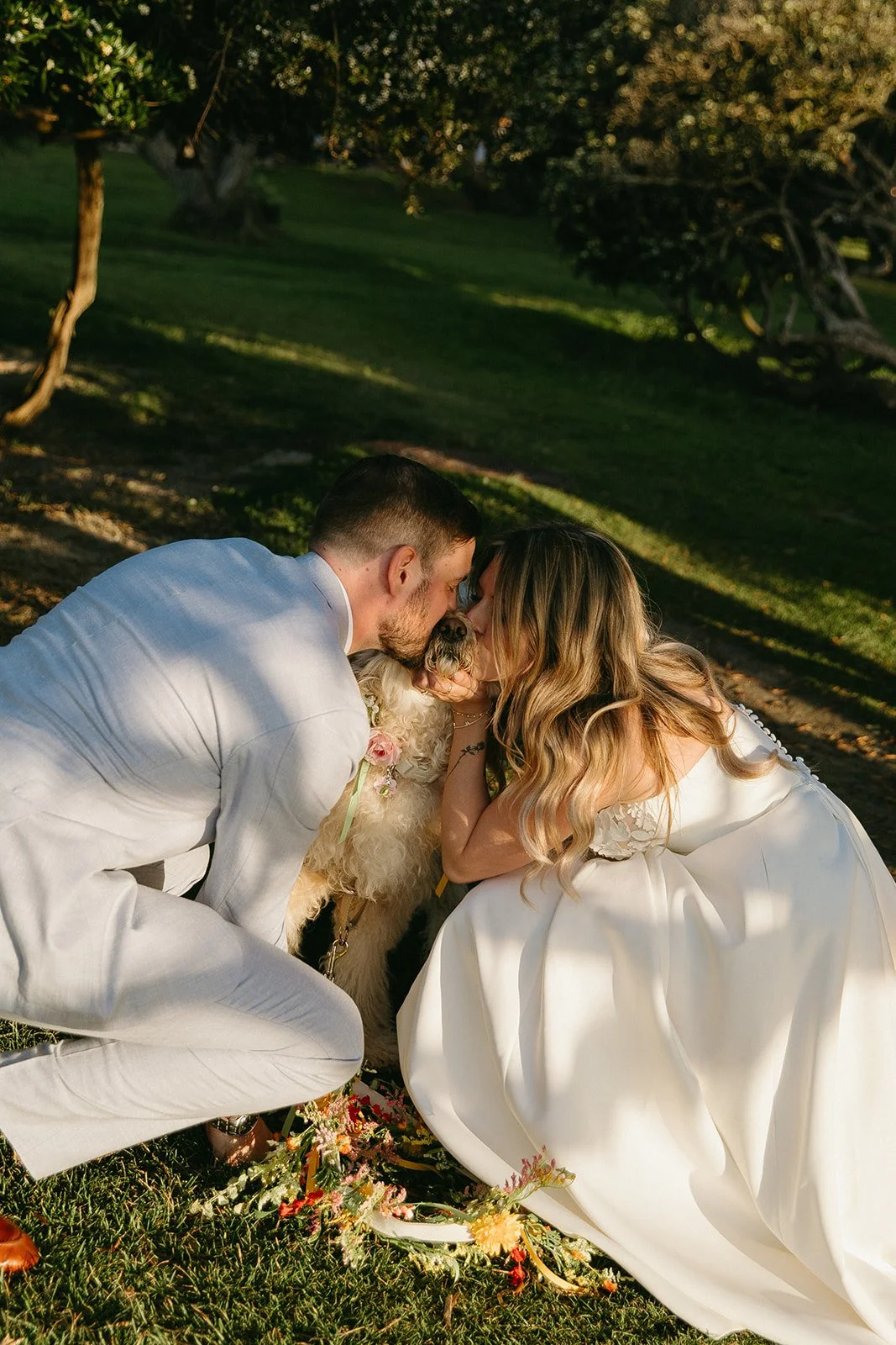 A bride and groom taking wedding photos with their dog