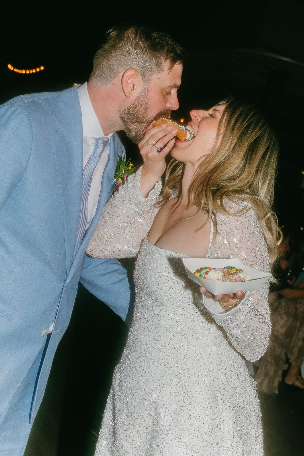 A bride and groom eating cannolis together