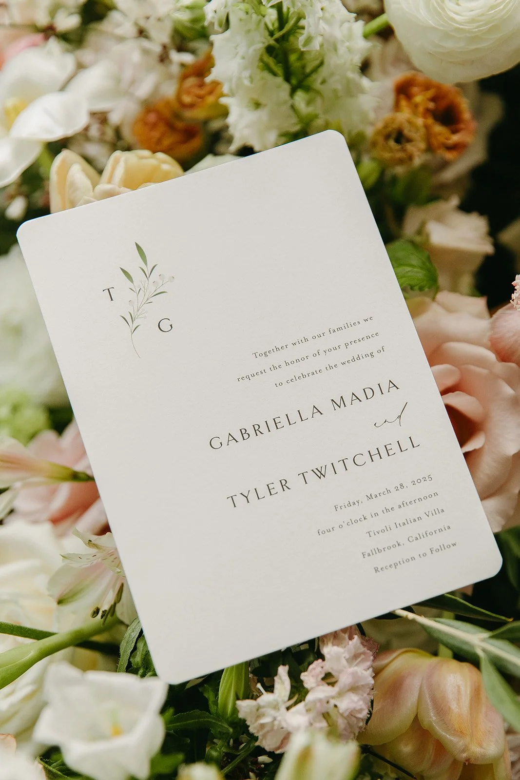 A wedding invitation lying on wedding flowers