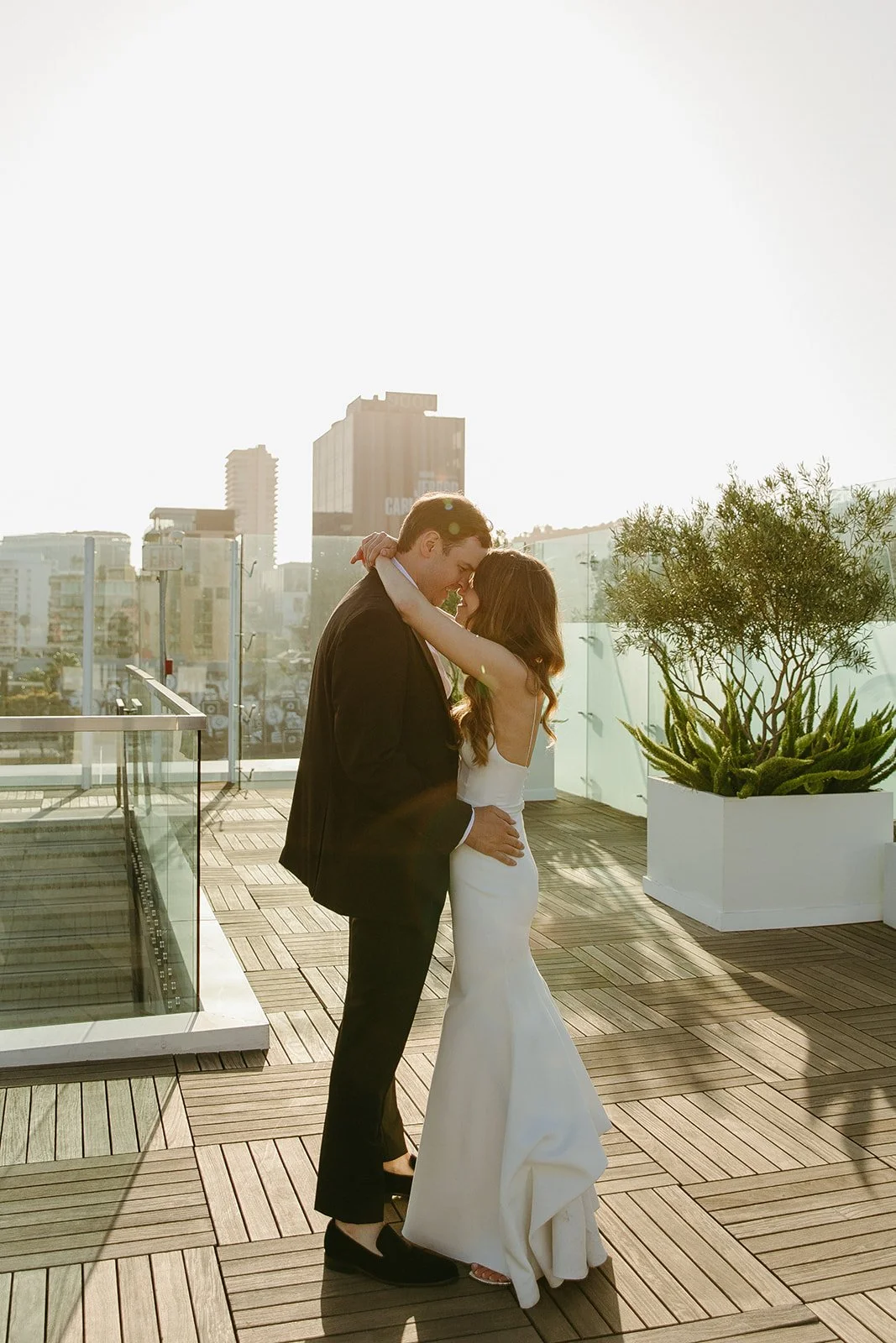 A couple posing for wedding photos on the rooftop of their West Hollywood wedding venue