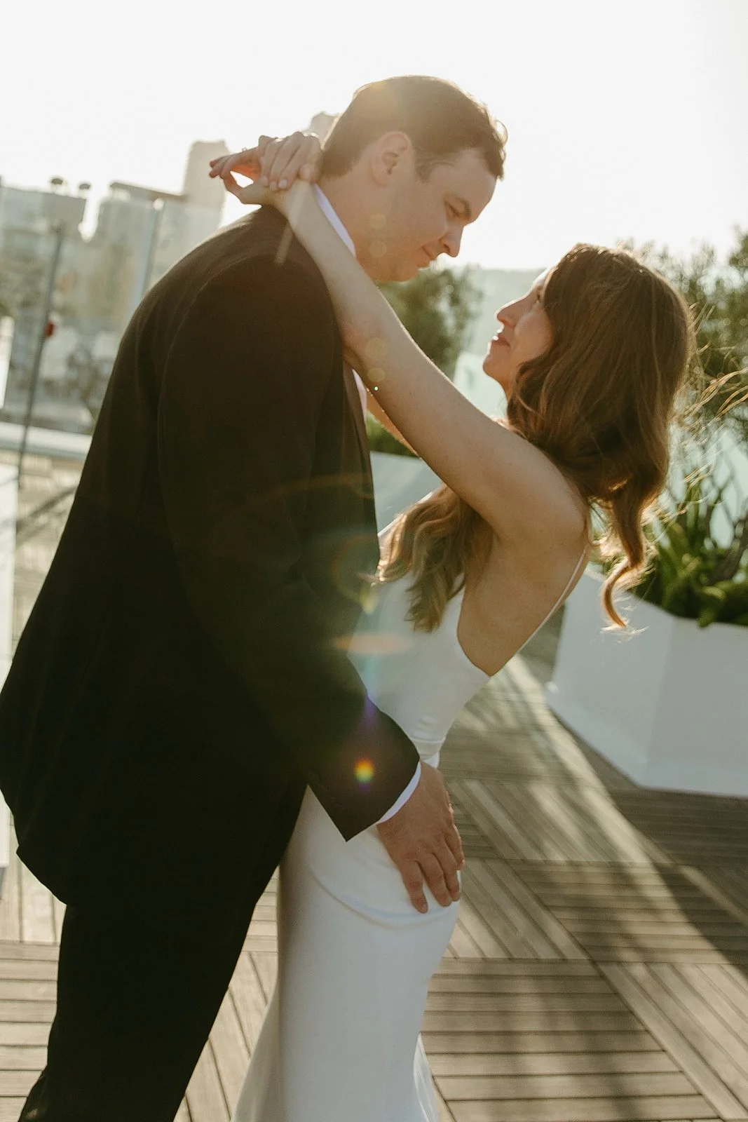 A couple posing for wedding photos on the rooftop of their West Hollywood wedding venue