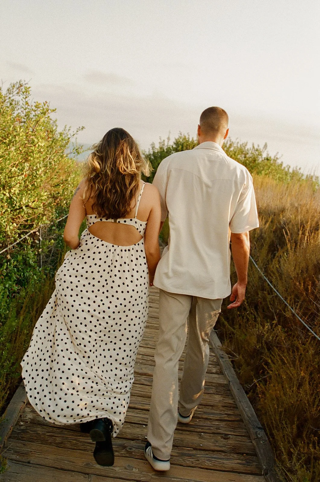 A couple walking down to the beach for engagement photos